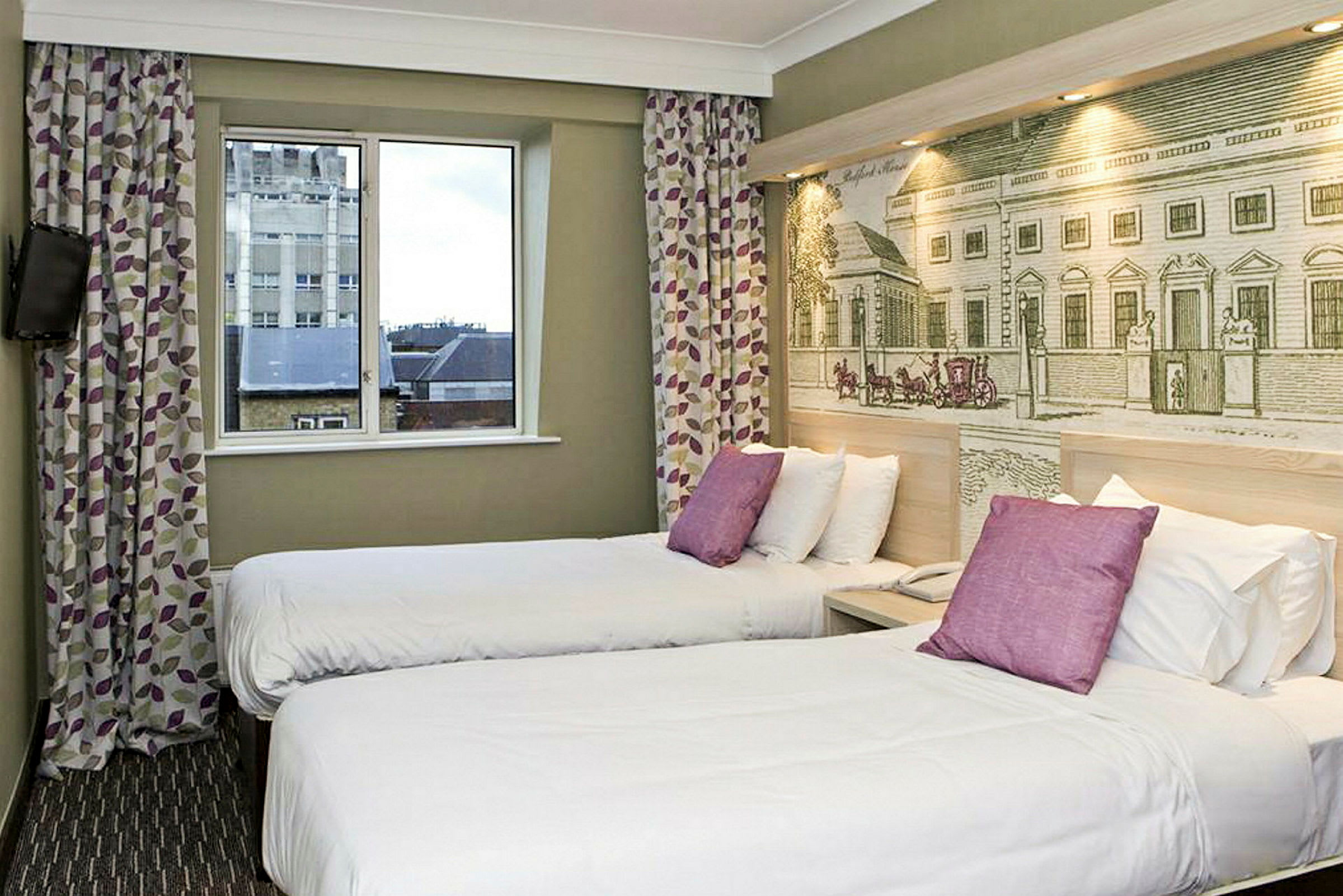 Et hotellrom med to enkeltsenger og dekorativ vegg bak sengene. (AI-generert tekst)