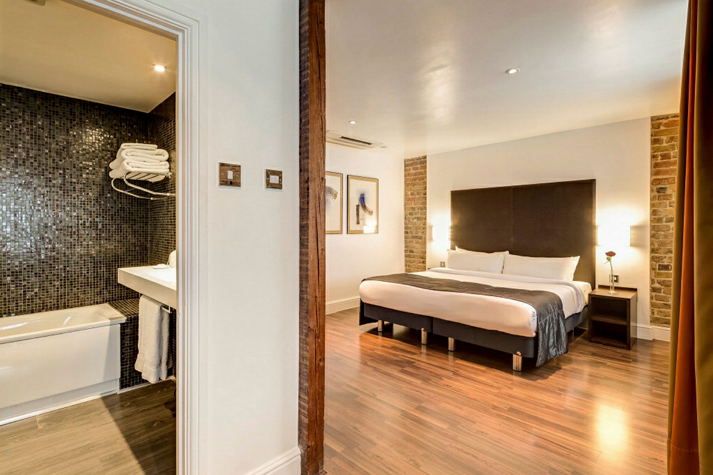 Hotellrom med dobbeltseng og tilstøtende bad. (AI-generert tekst)