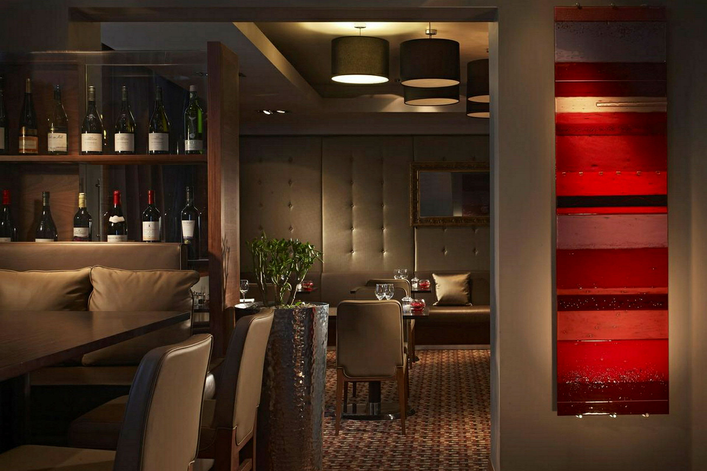 Interiør av en restaurant med vinflasker, sitteplasser og dekorative detaljer. (AI-generert tekst)
