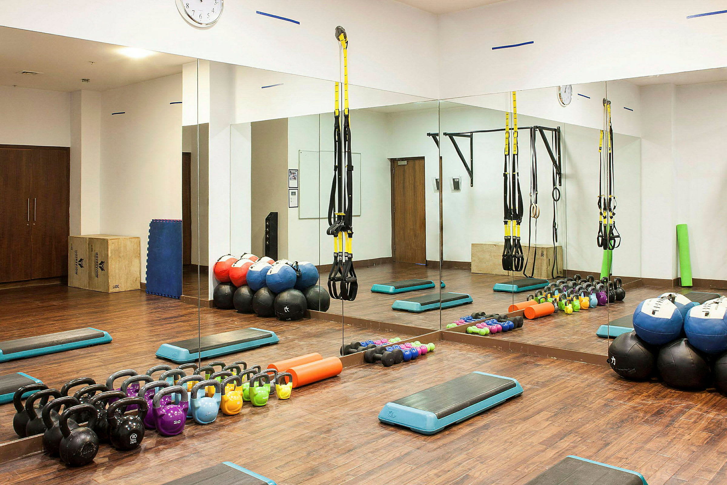 Et treningsrom med treningsutstyr som kettlebells, medisinballer og stropper. (AI-generert tekst)
