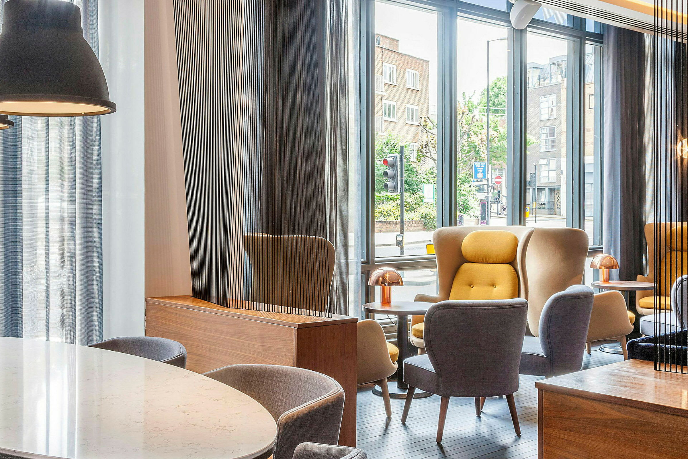 En moderne lounge med store vinduer og komfortable sittemøbler. (AI-generert tekst)