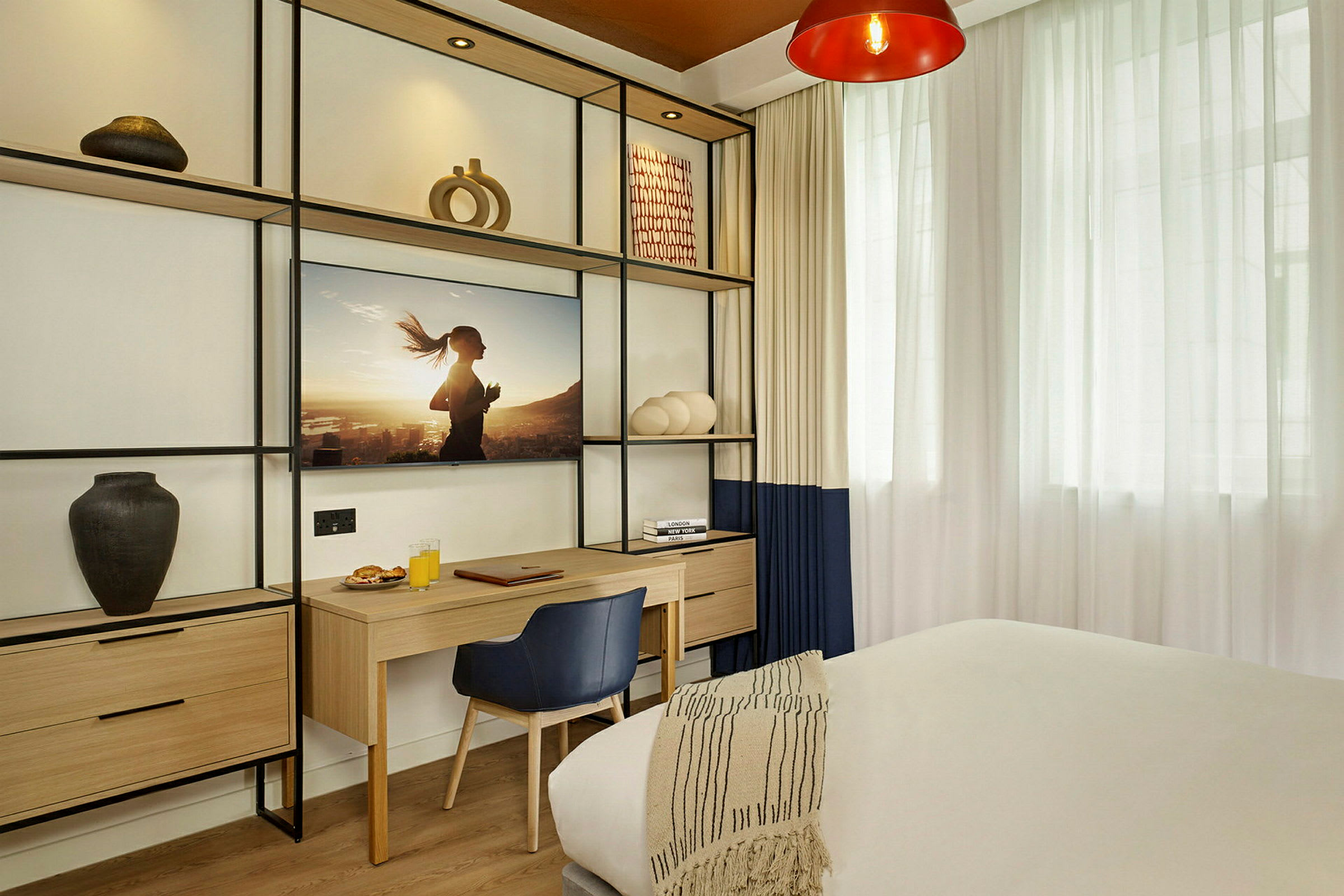 Moderne innredet hotellrom med skrivebord og dekorative hyller. (AI-generert tekst)