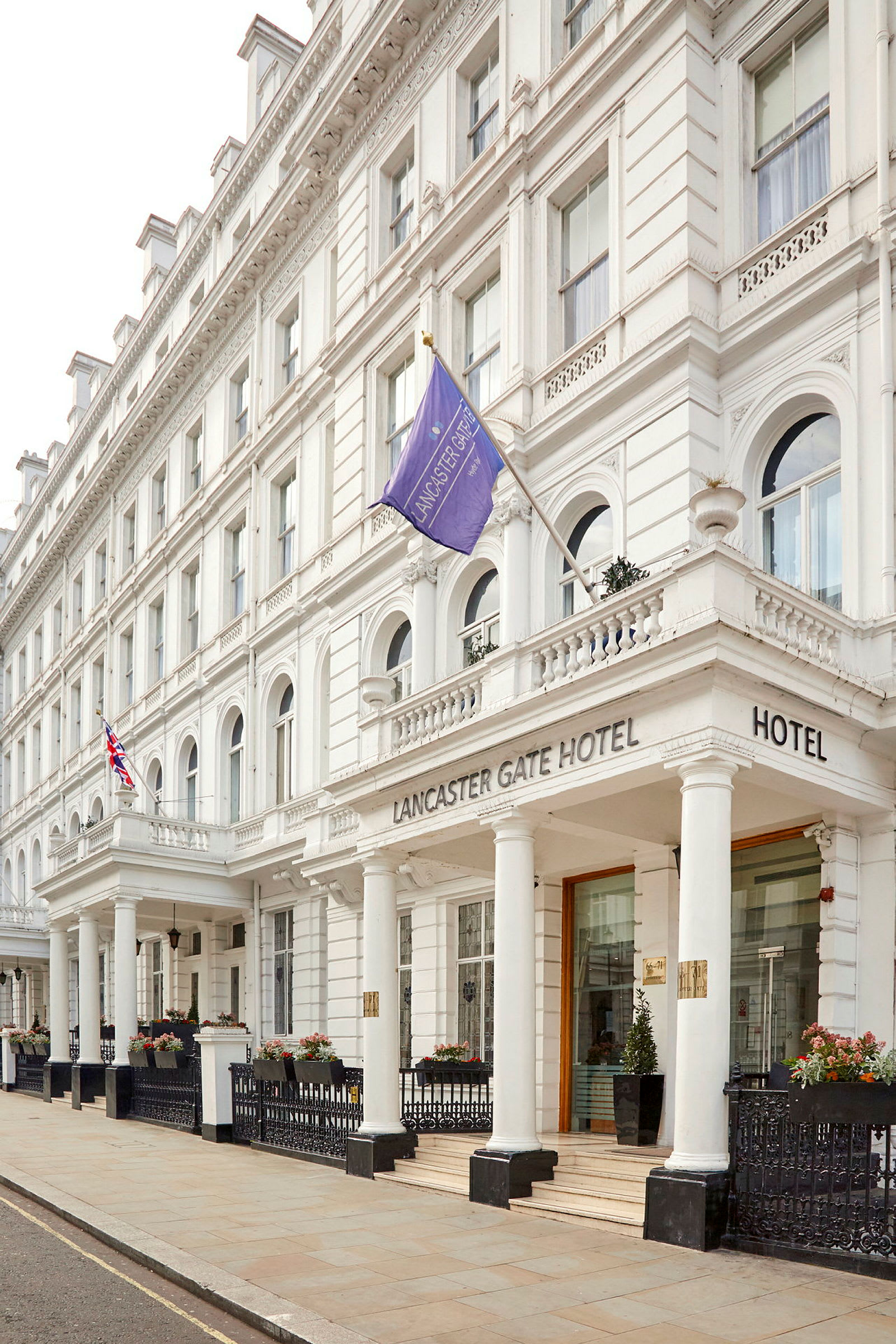 Hotellet Lancaster Gate sett fra gaten, med hvite detaljer og søyler. (AI-generert tekst)