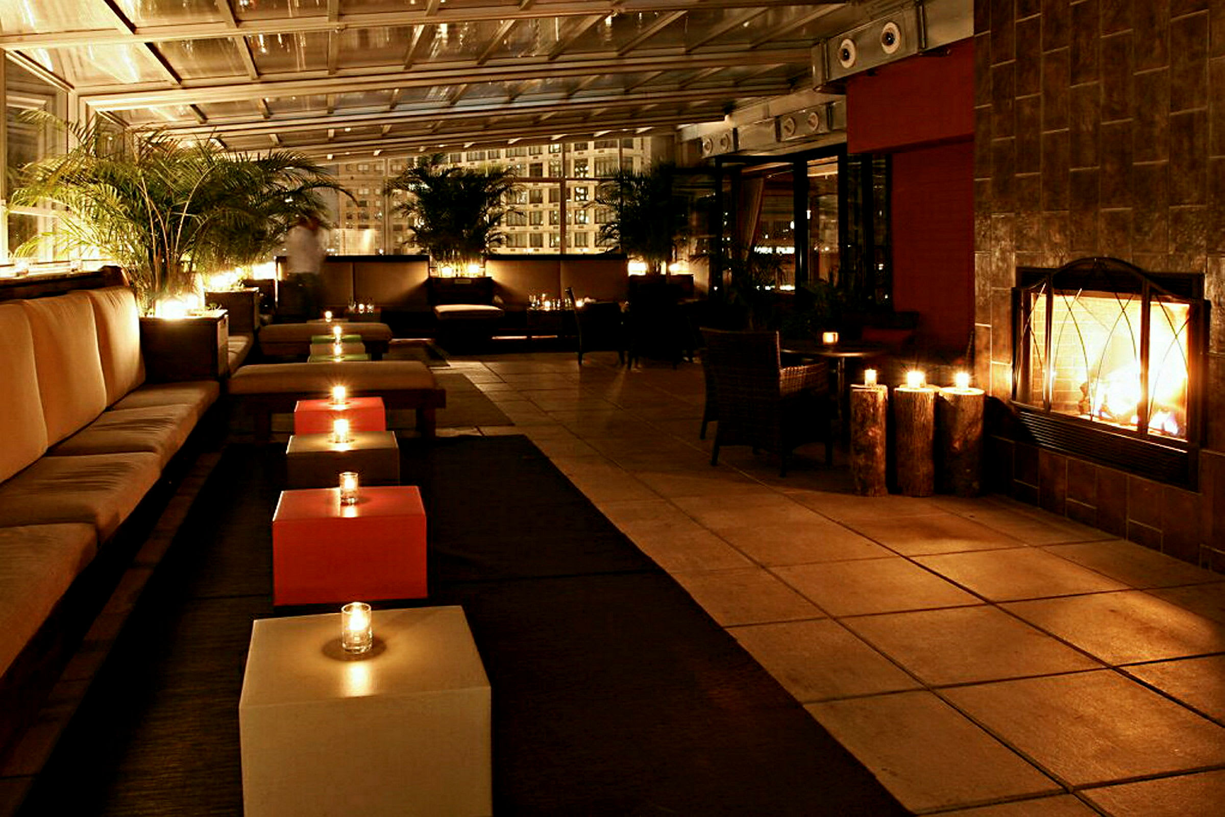 Et moderne opplyst loungeområde med sofaer, lave bord og en brennende peis. (AI-generert tekst)