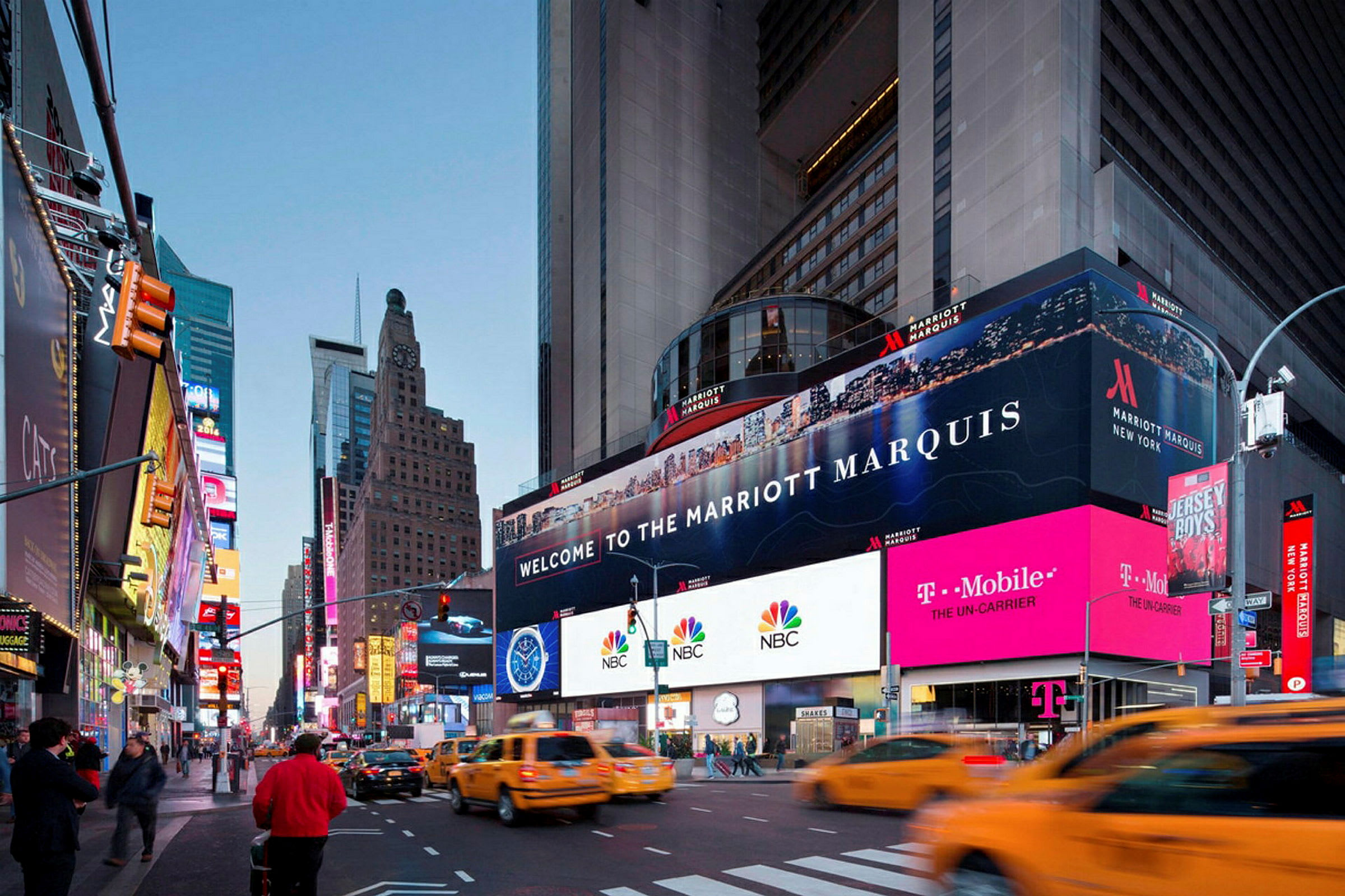 Et livlig bybilde med skyskrapere, neonskilt og gule taxier, med en reklameplakat for Marriott Marquis. (AI-generert tekst)
