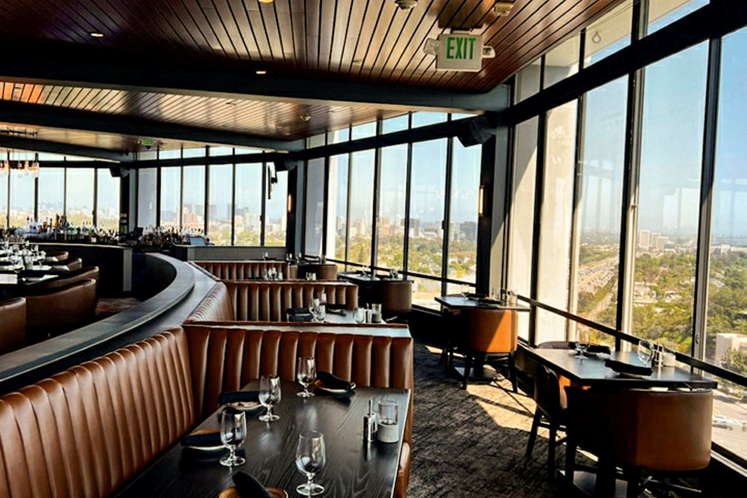 Interiør av en romslig restaurant med panoramautsikt gjennom store vinduer. (AI-generert tekst)