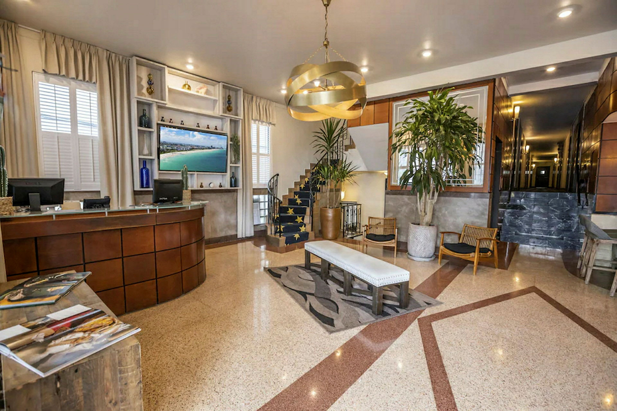Hotellobby med resepsjonsdisk, sitteområde og en trapp. (AI-generert tekst)