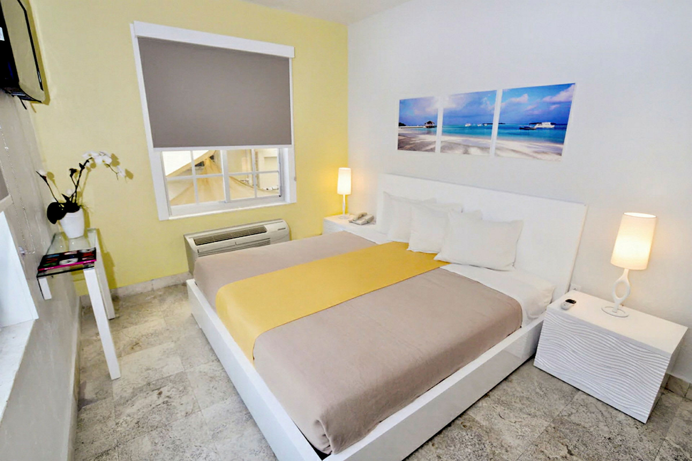 Et hotellrom med en dobbeltseng, hvit innredning og dekorasjoner. (AI-generert tekst)