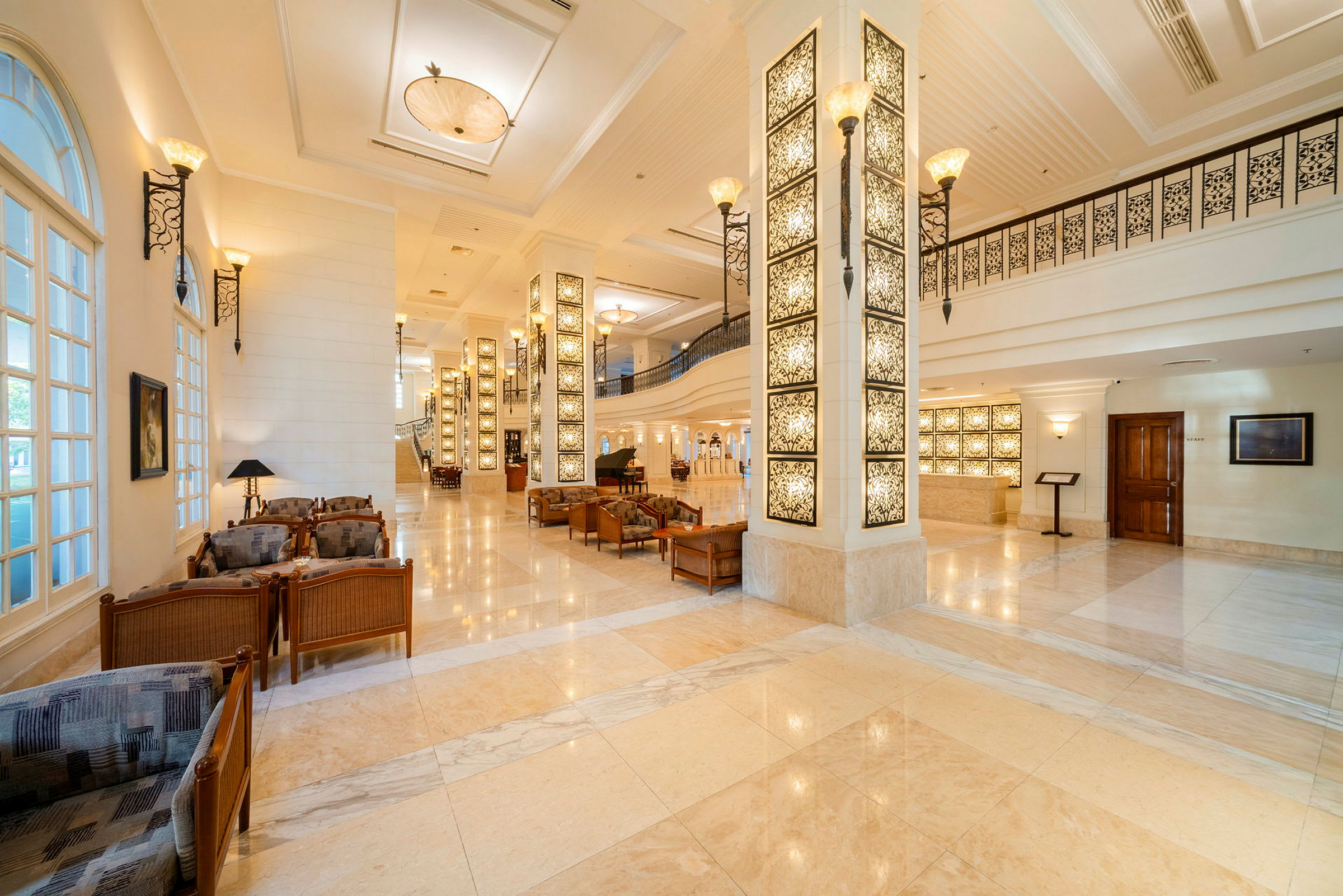 Elegant hotellobby med marmorgulv, dekorative søyler og sitteområder. (AI-generert tekst)