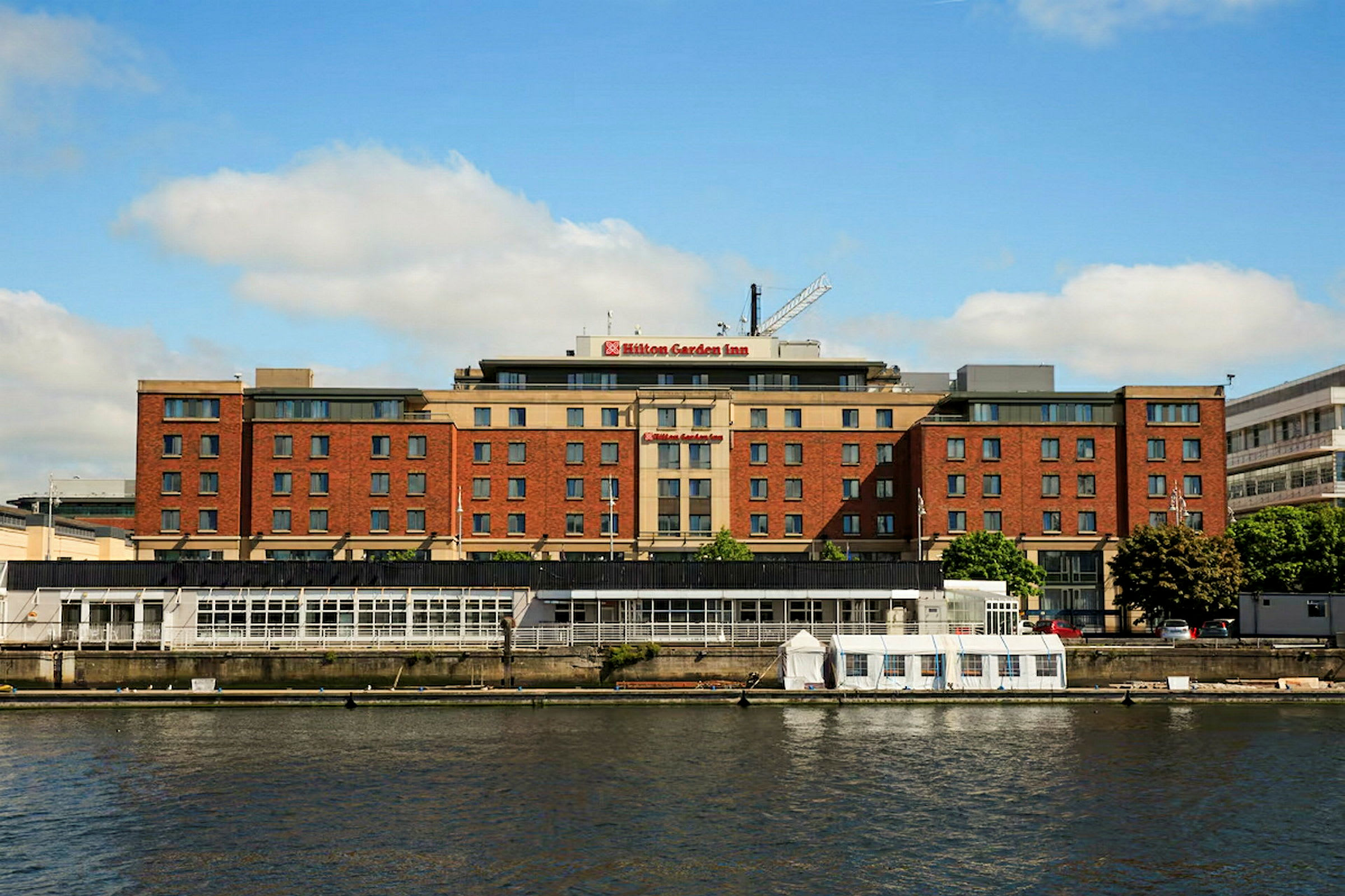 En bygning merket som Hilton Garden Inn ved en vannsamling. (AI-generert tekst)