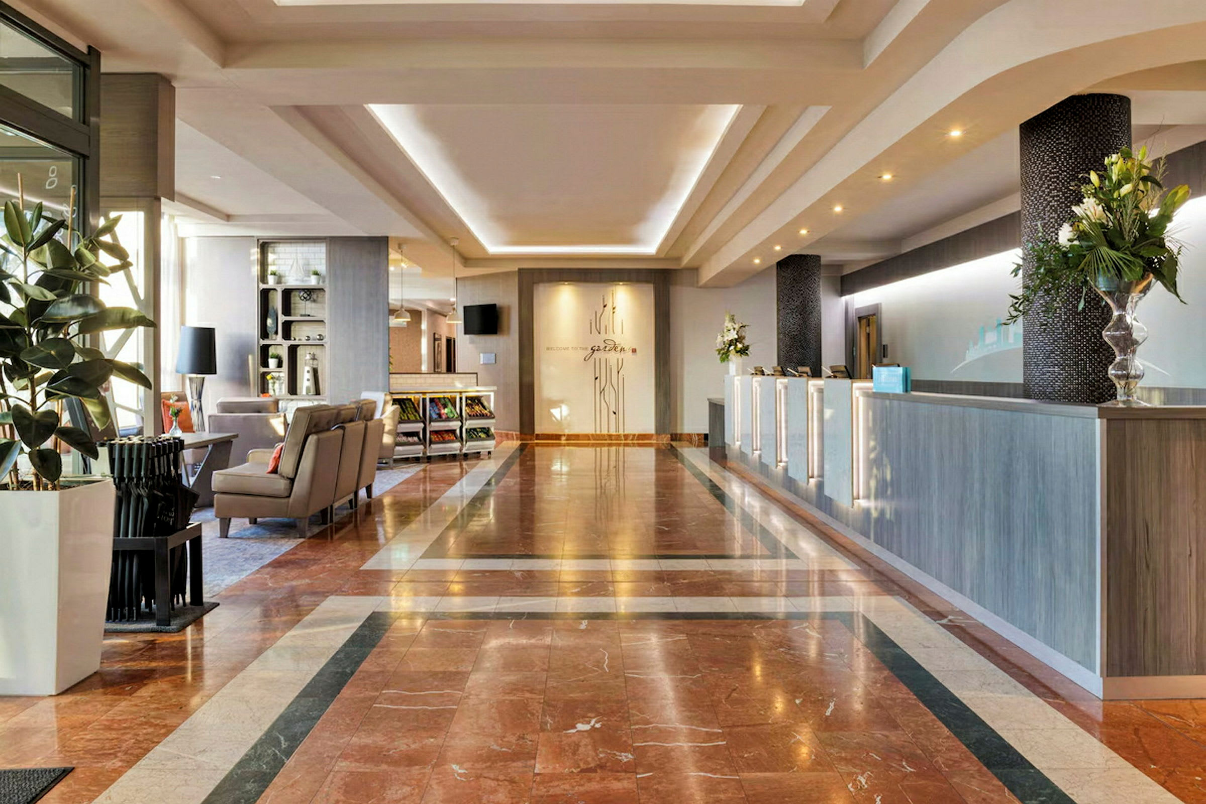 Hotellobby med marmorgulv, resepsjon og sittegruppe. (AI-generert tekst)