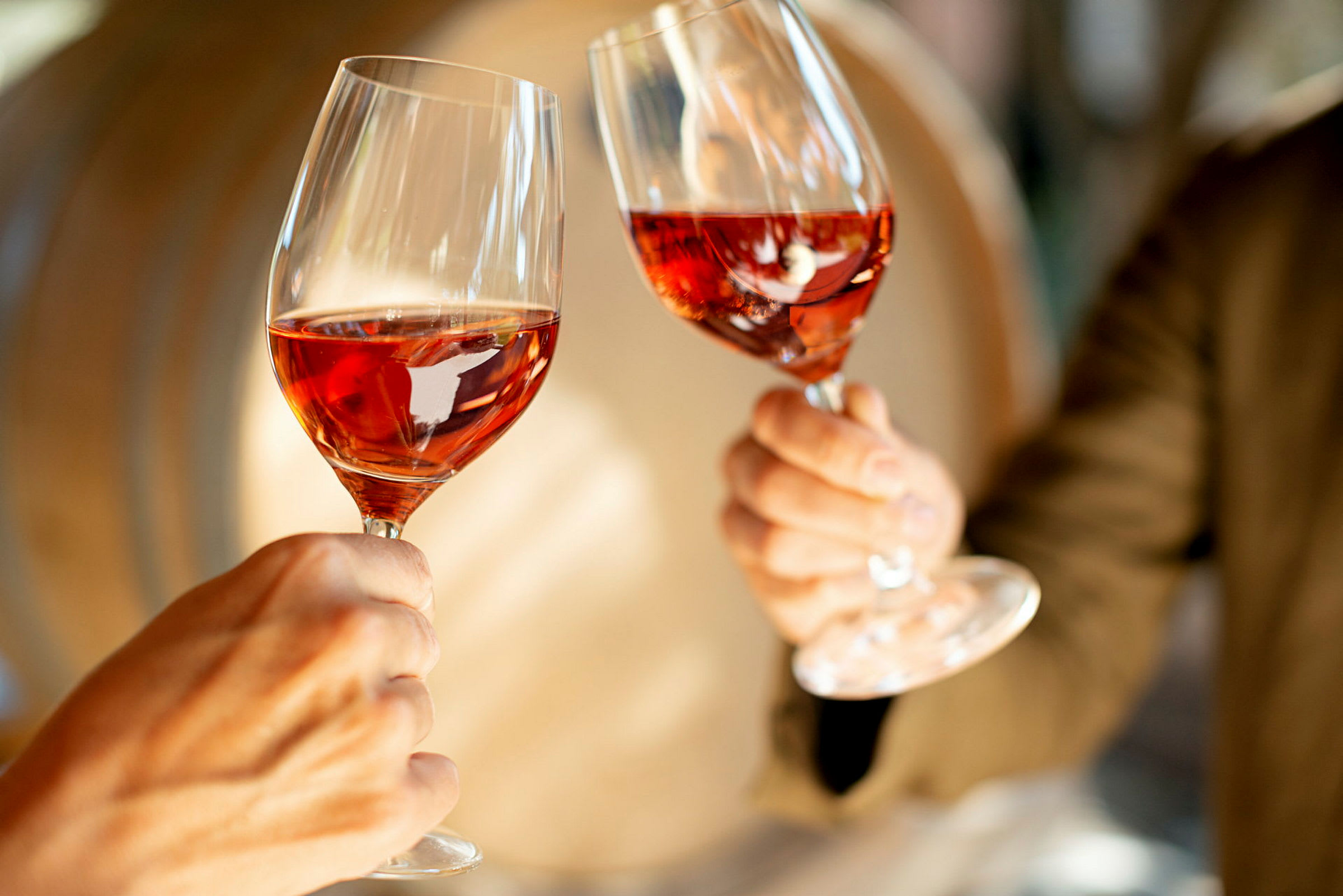 To glass med rosévin holdes opp. (AI-generert tekst)