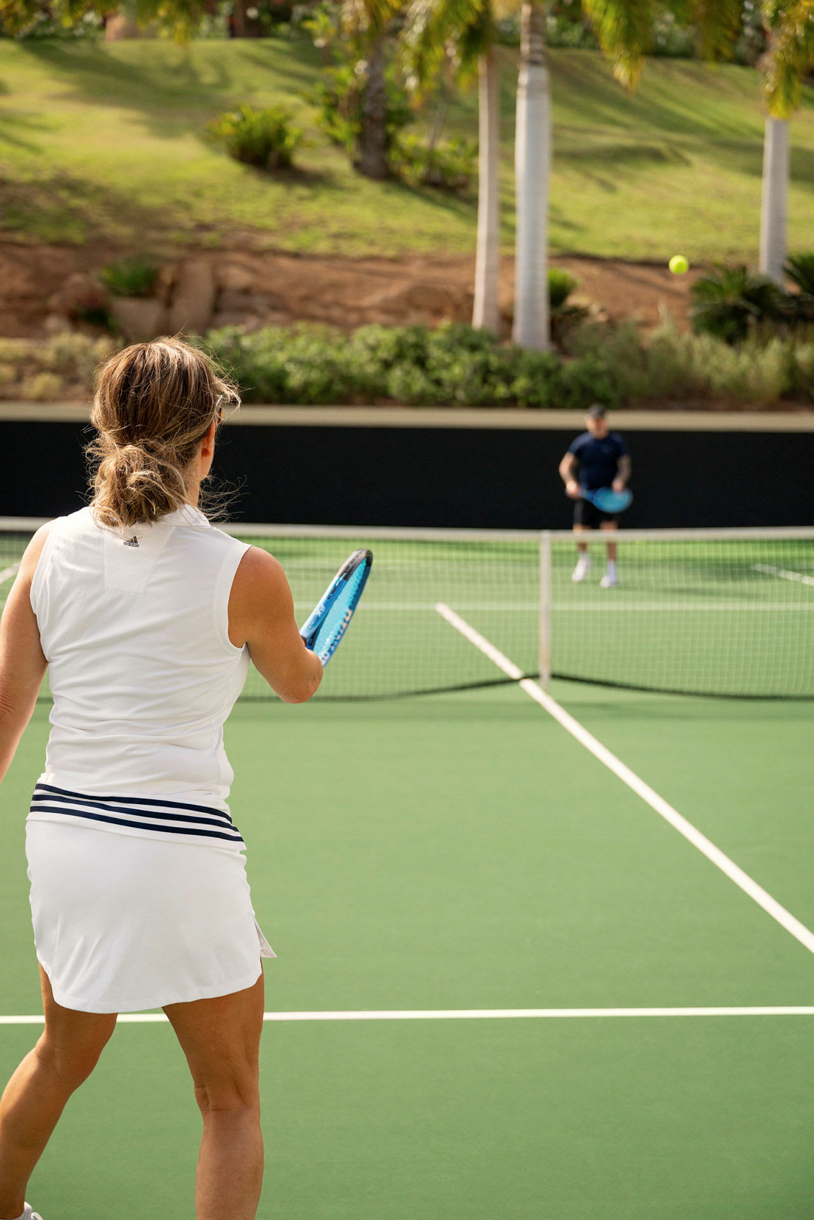 En kvinne spiller tennis på en utendørs bane. (AI-generert tekst)