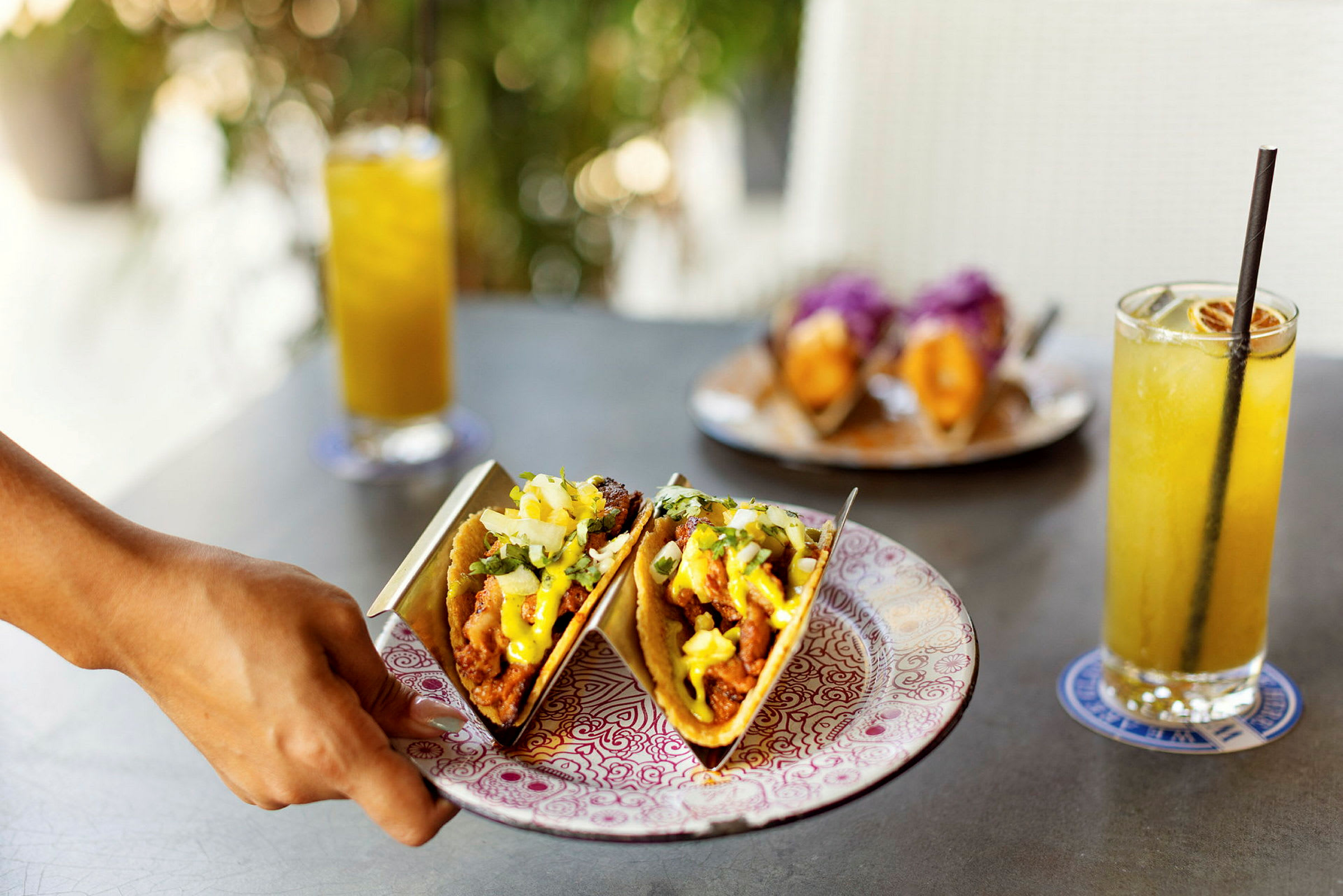 To tacos på en tallerken med drikke i bakgrunnen. (AI-generert tekst)