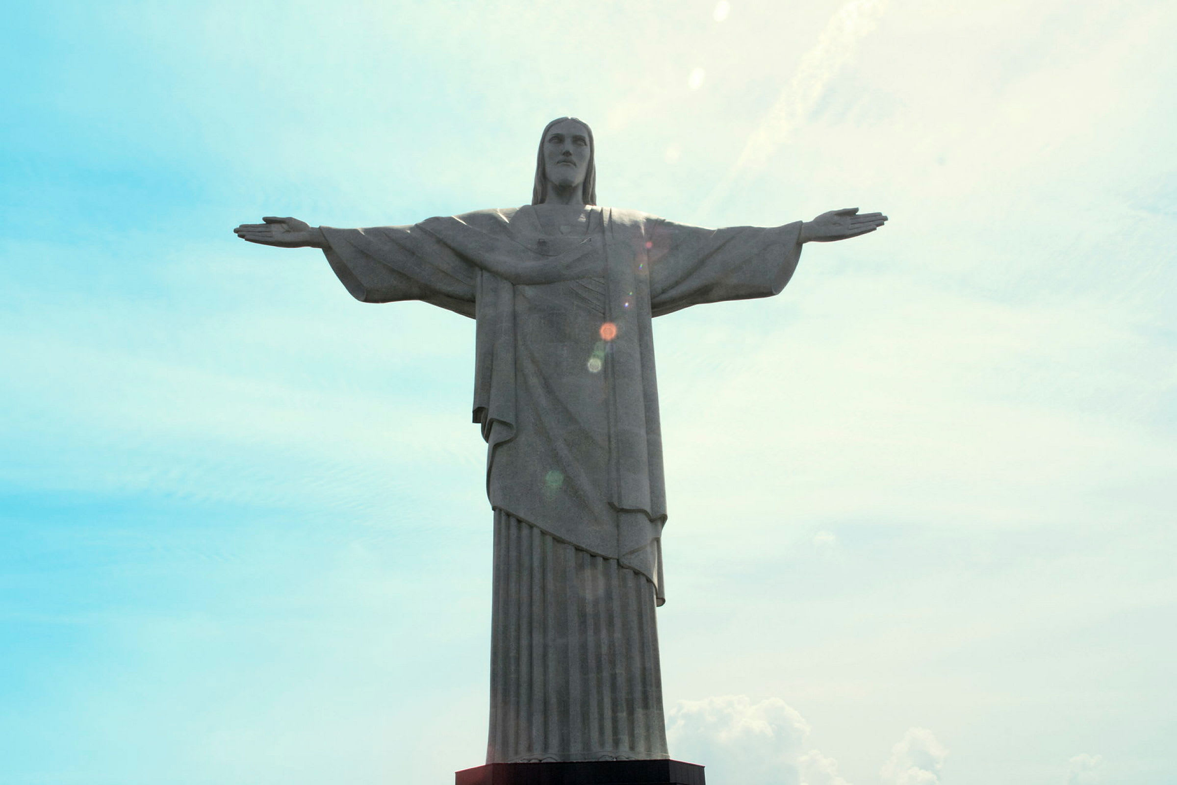 En statue av en person med utstrakte armer med en himmel i bakgrunnen. (AI-generert tekst)