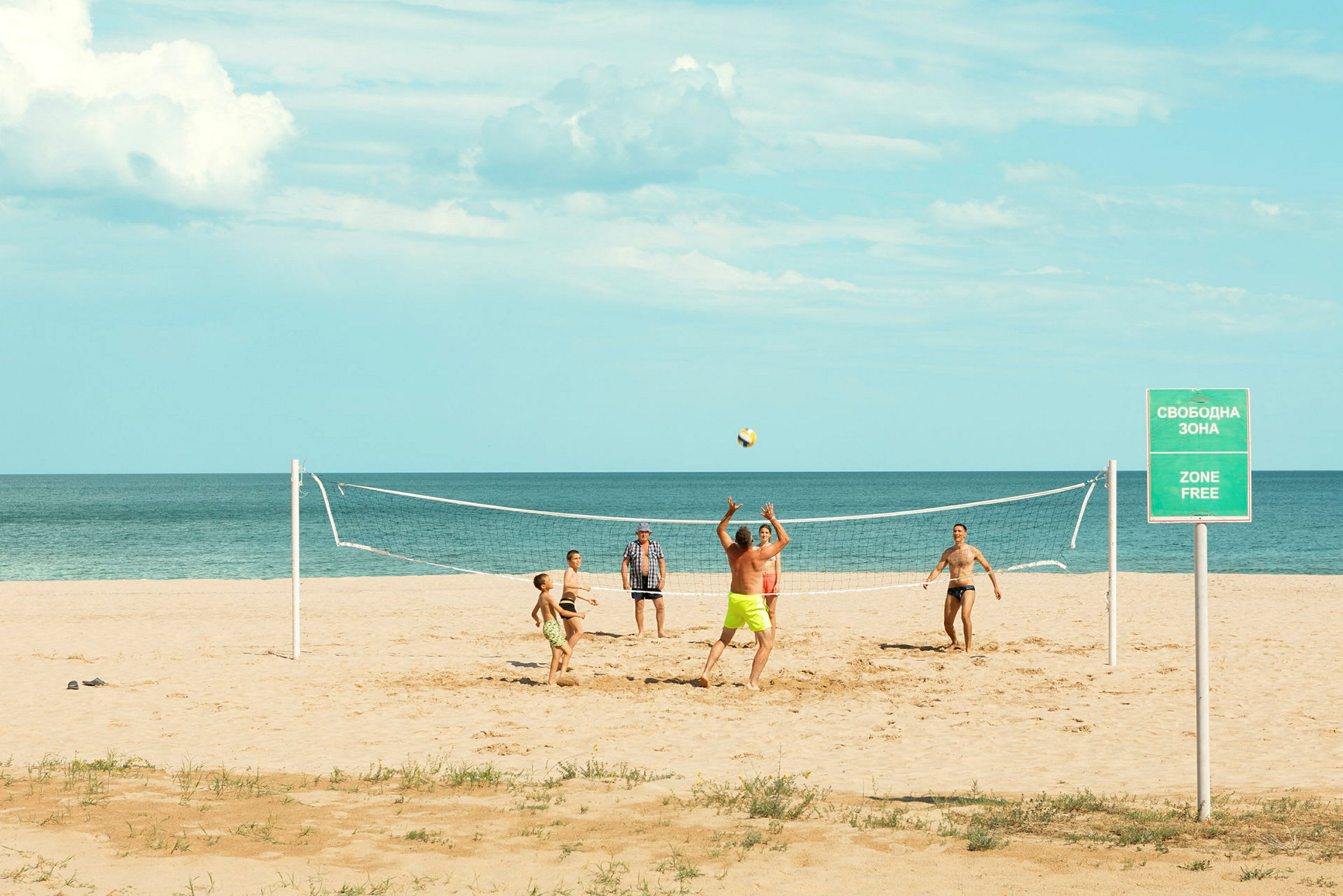 Folk spiller sandvolleyball på stranden. (AI-generert tekst)