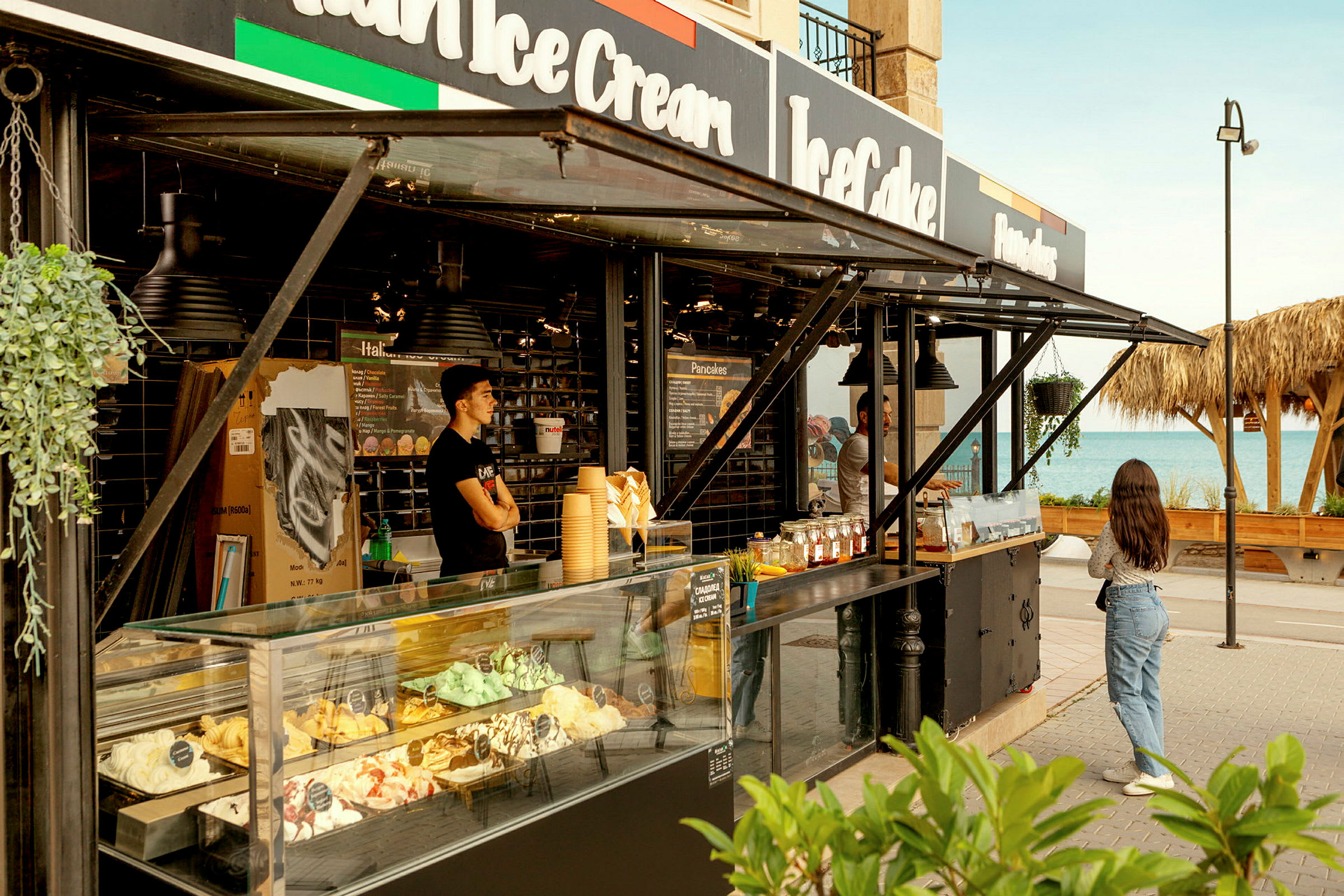 En iskremkiosk ved stranden med ulike smaker utstilt. (AI-generert tekst)
