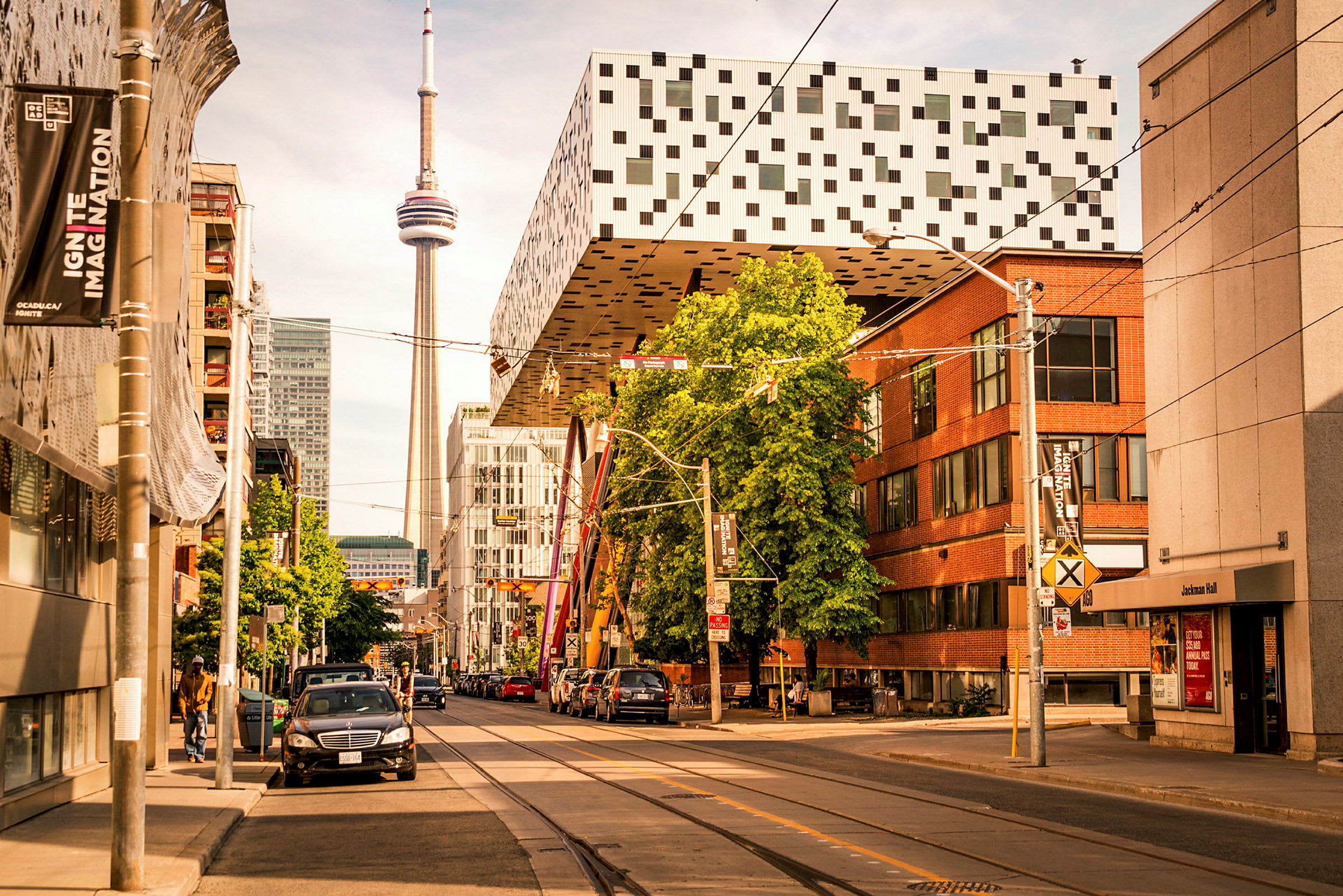 Gate med bygninger, parkering og CN Tower i bakgrunnen. (AI-generert tekst)