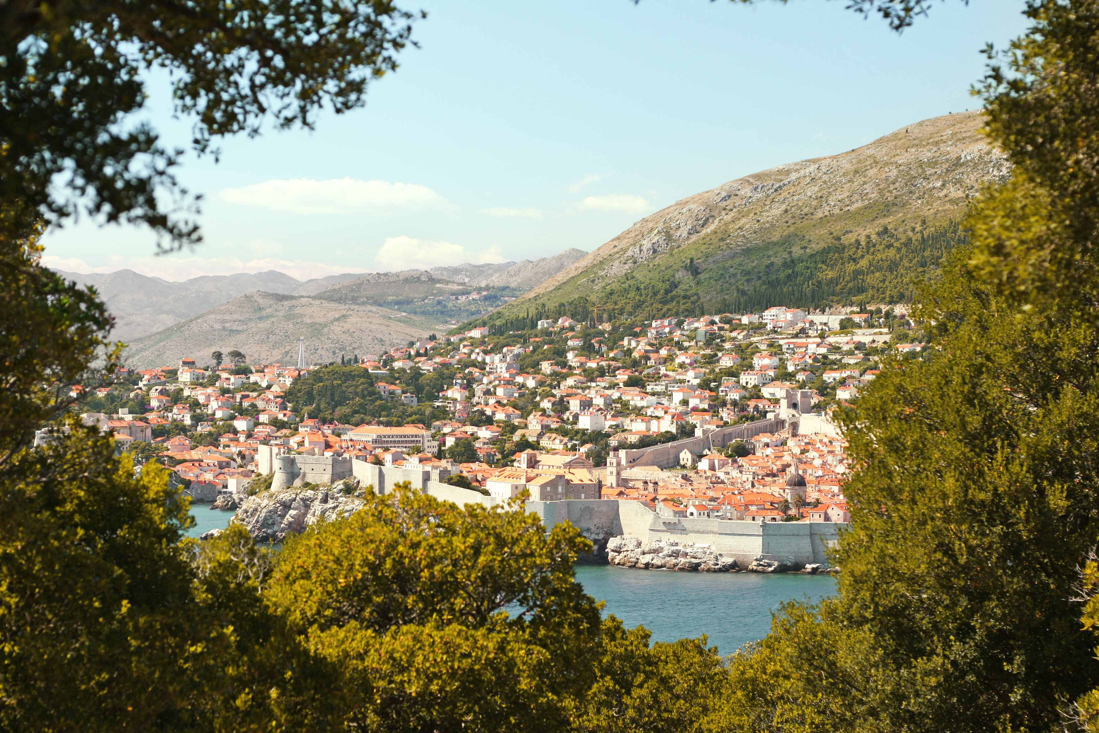 En utsikt over Dubrovnik med sin historiske bymur, omgitt av grøntområder. (AI-generert tekst)