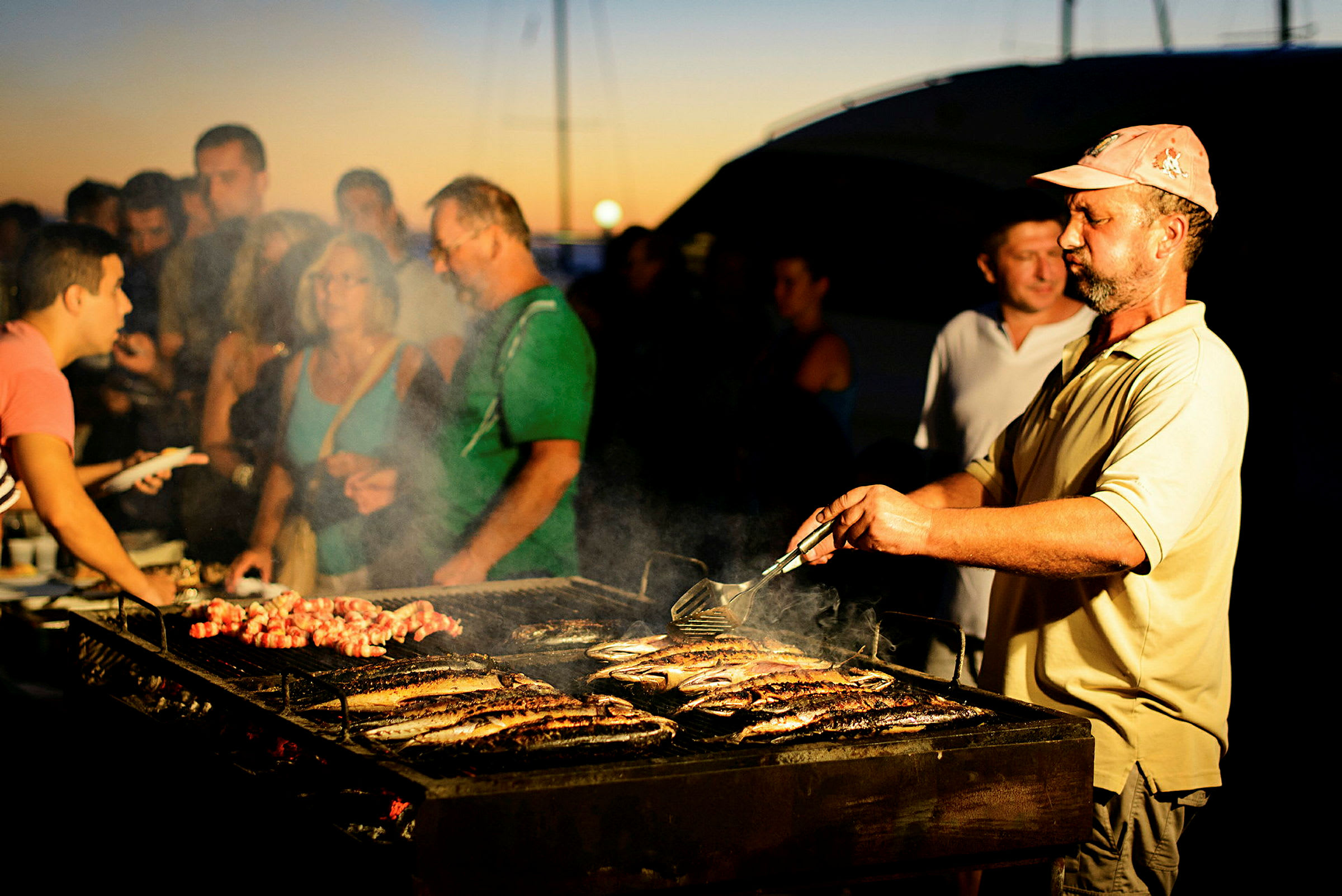 Person tilbereder mat på en grill utendørs. (AI-generert tekst)