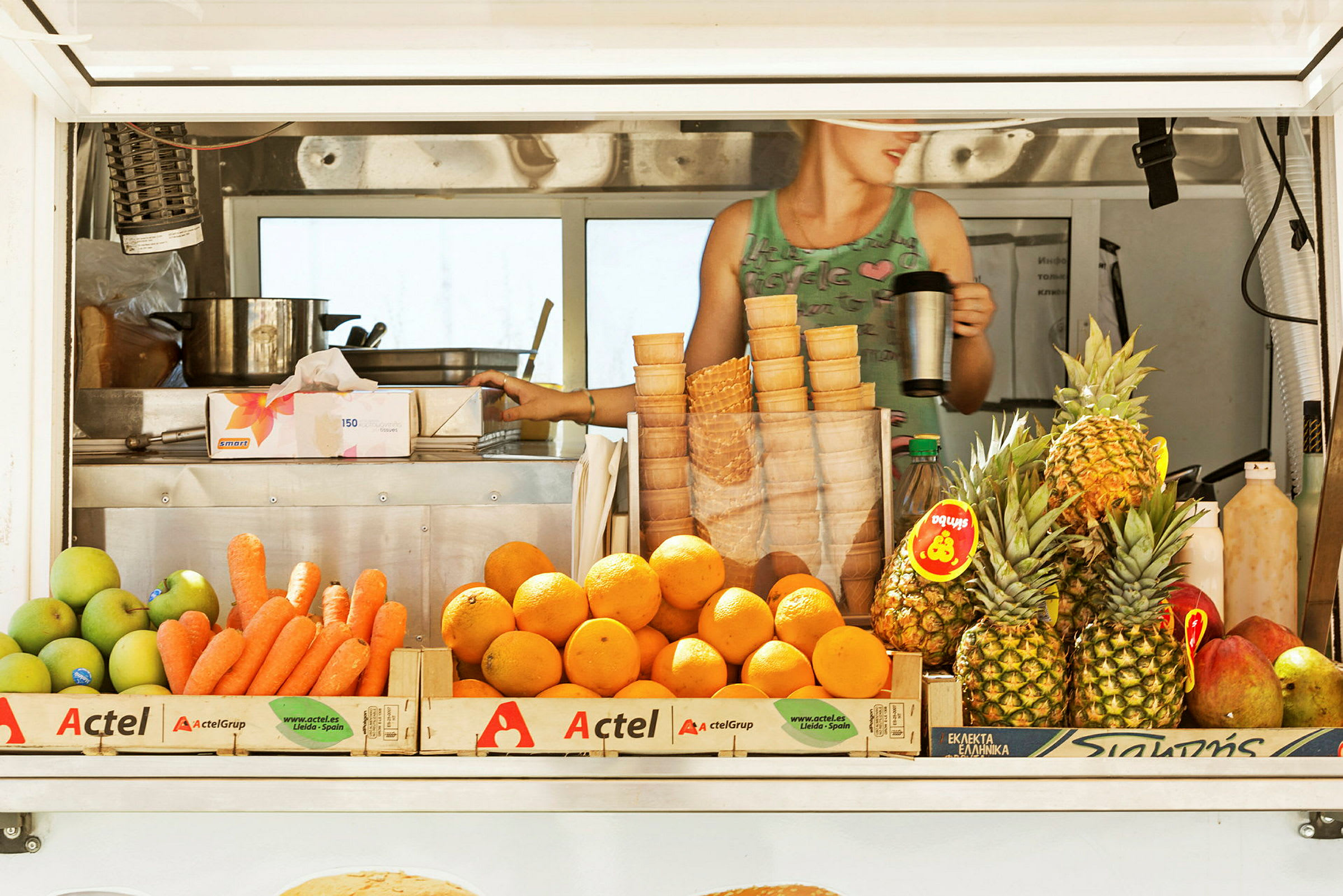 En markedsbod med frukt, inkludert gulrøtter, appelsiner og ananas. (AI-generert tekst)