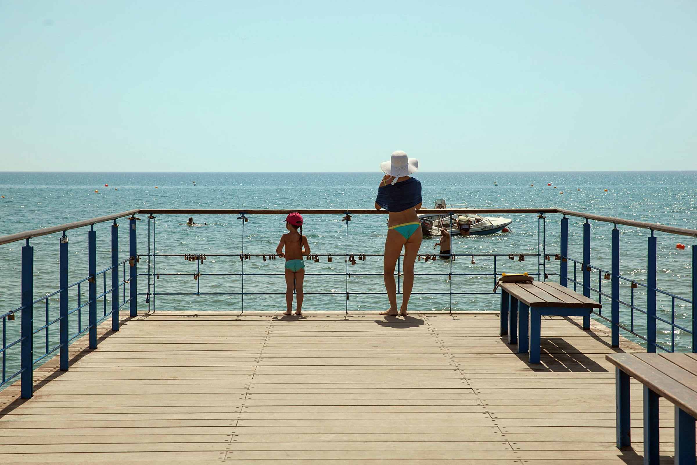 En kvinne og et barn står på en brygge og ser utover havet. (AI-generert tekst)