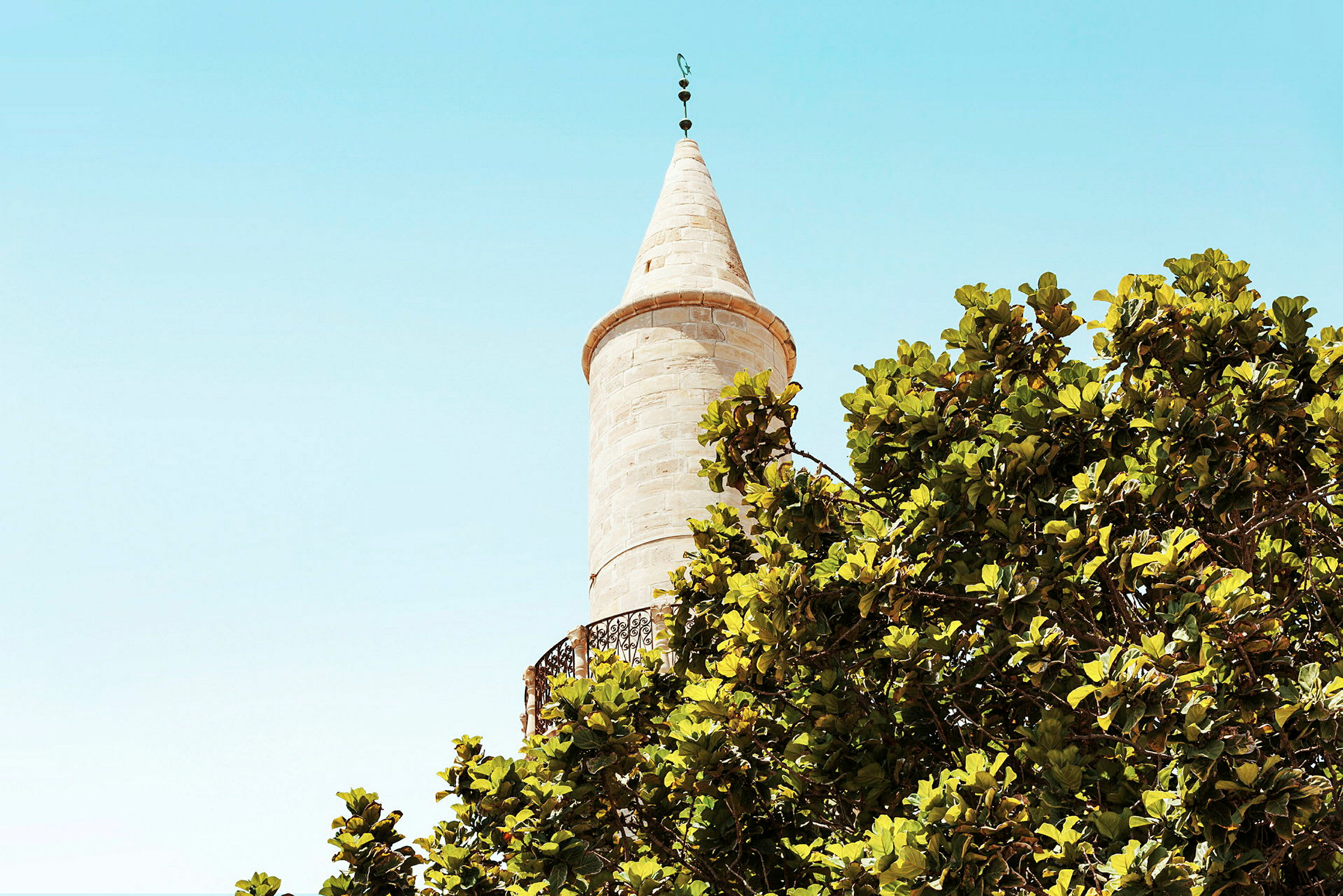 En minaret med trær i forgrunnen. (AI-generert tekst)