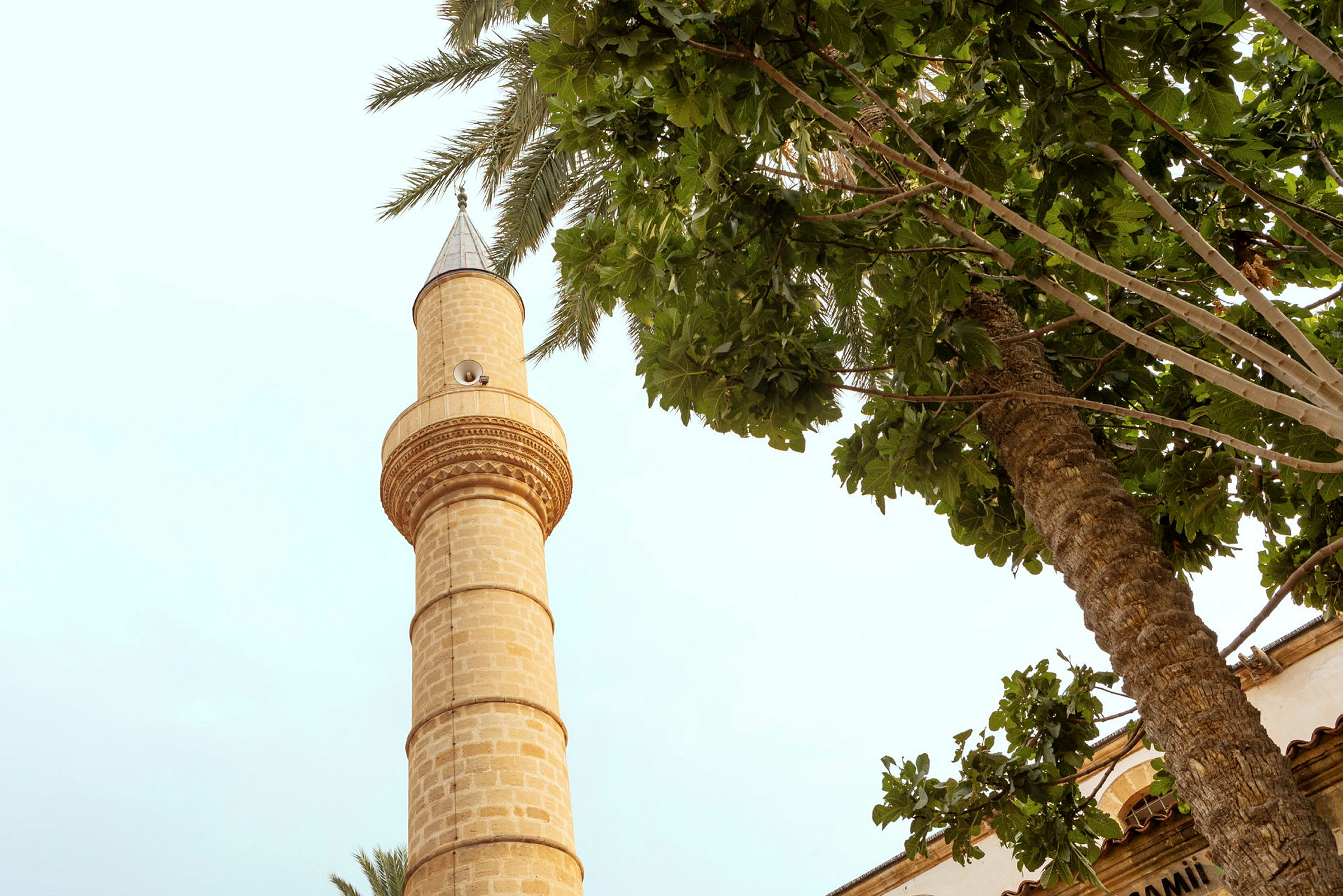 En minaret ved siden av tretopper. (AI-generert tekst)