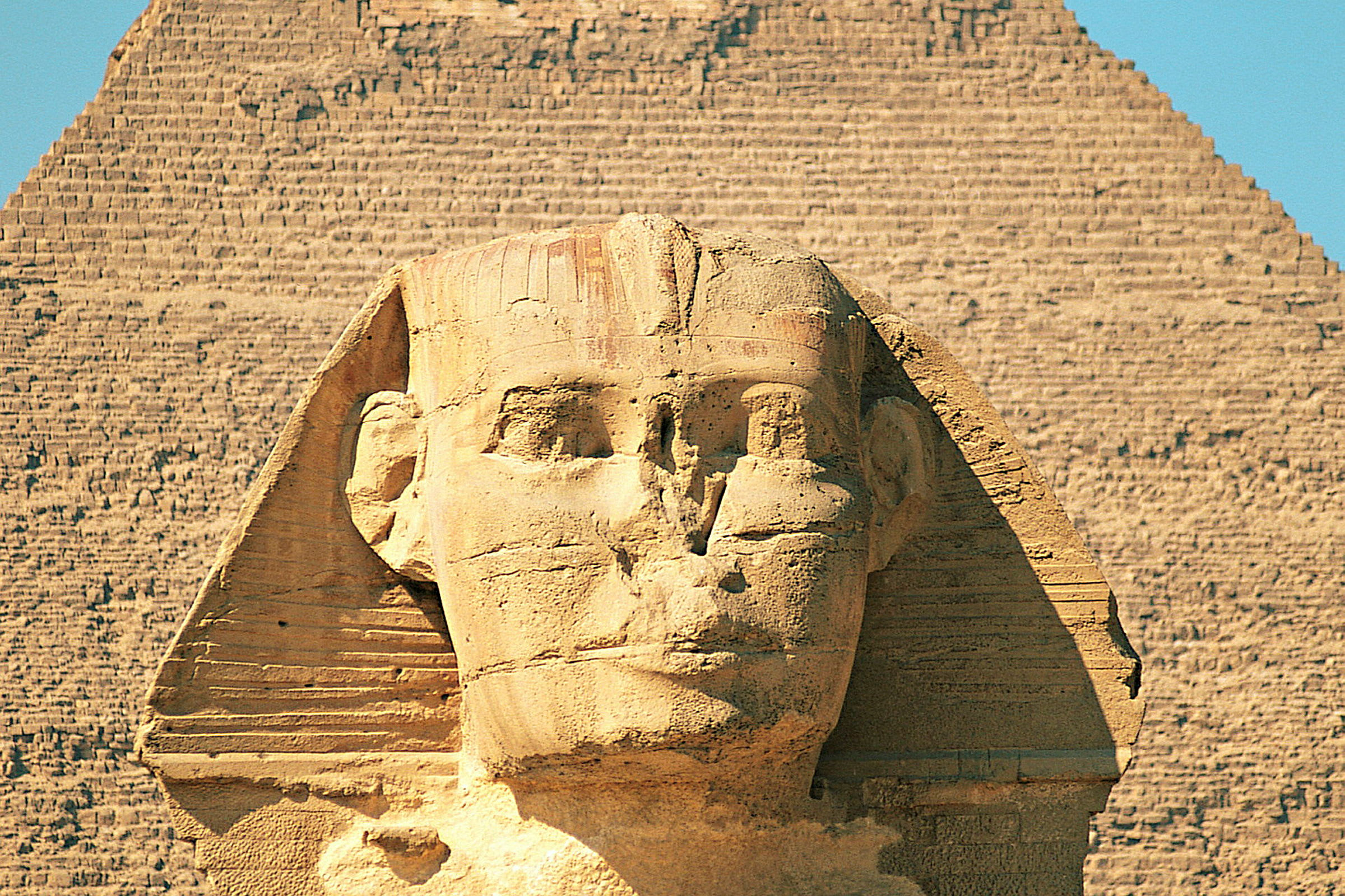 Bilde av Sfinksen i Giza med en pyramide i bakgrunnen. (AI-generert tekst)