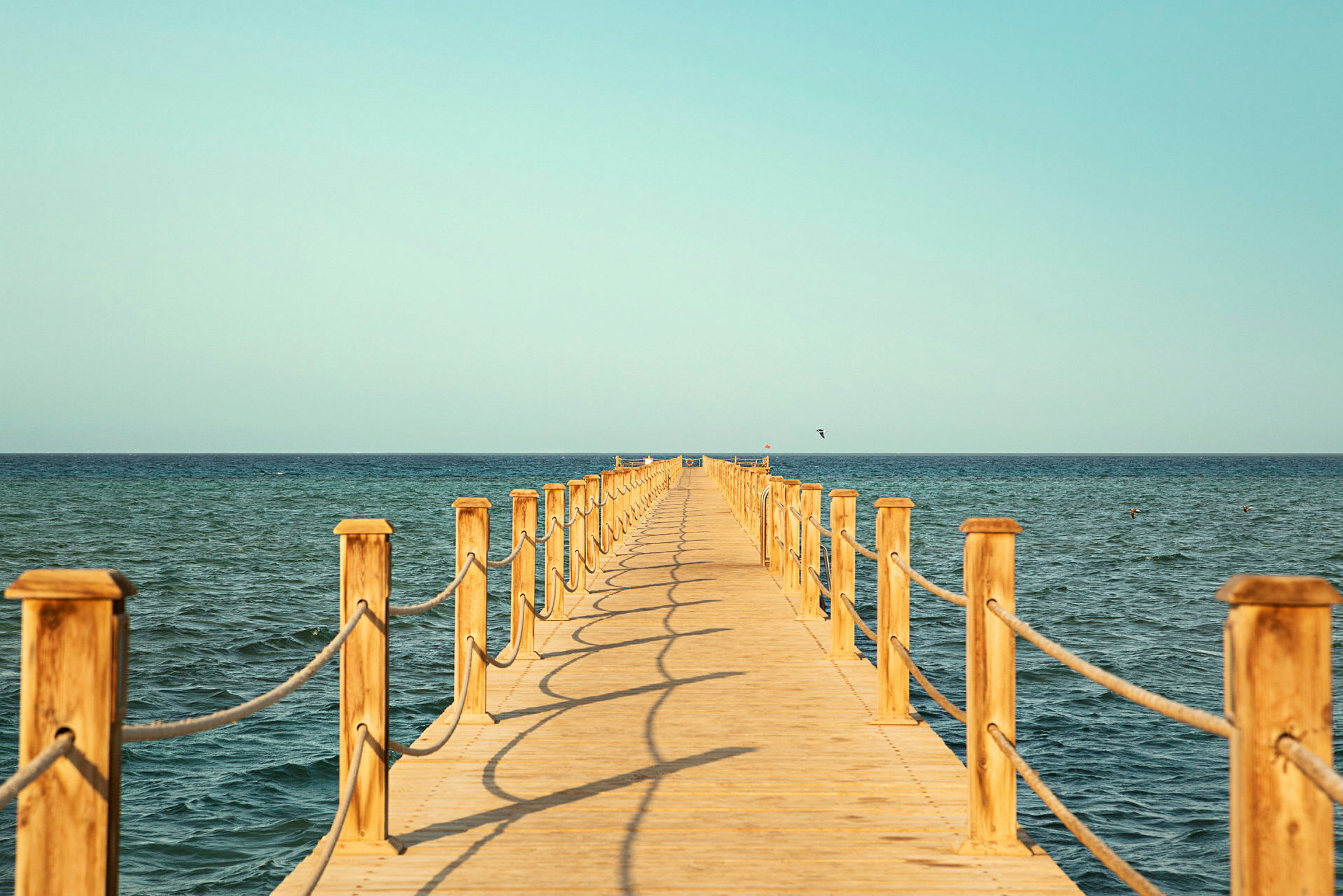 Trebro som strekker seg utover havet. (AI-generert tekst)