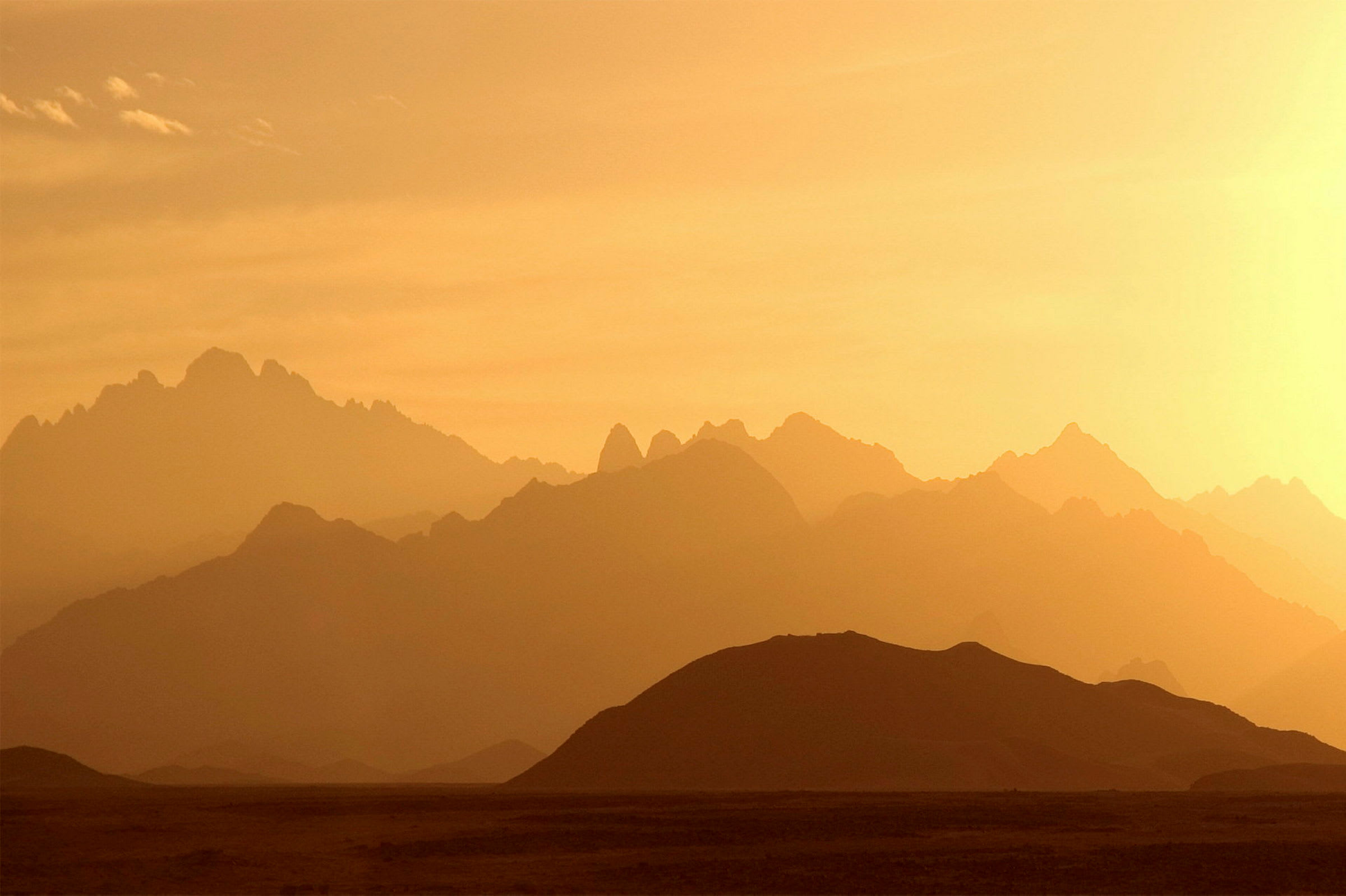 Fjellandskap ved solnedgang med skarpe silhuetter. (AI-generert tekst)