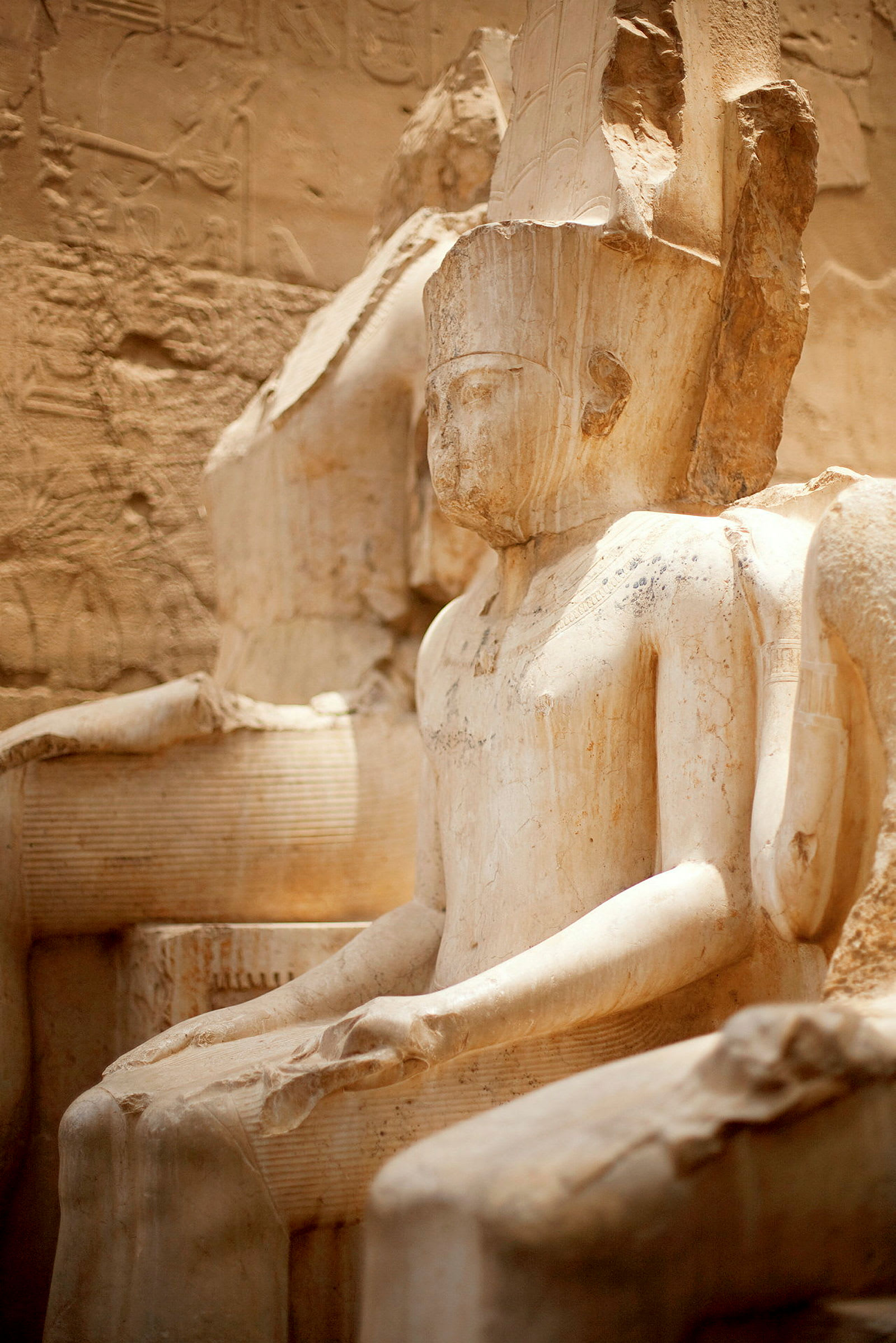 En gammel egyptisk statue av en sittende person. (AI-generert tekst)