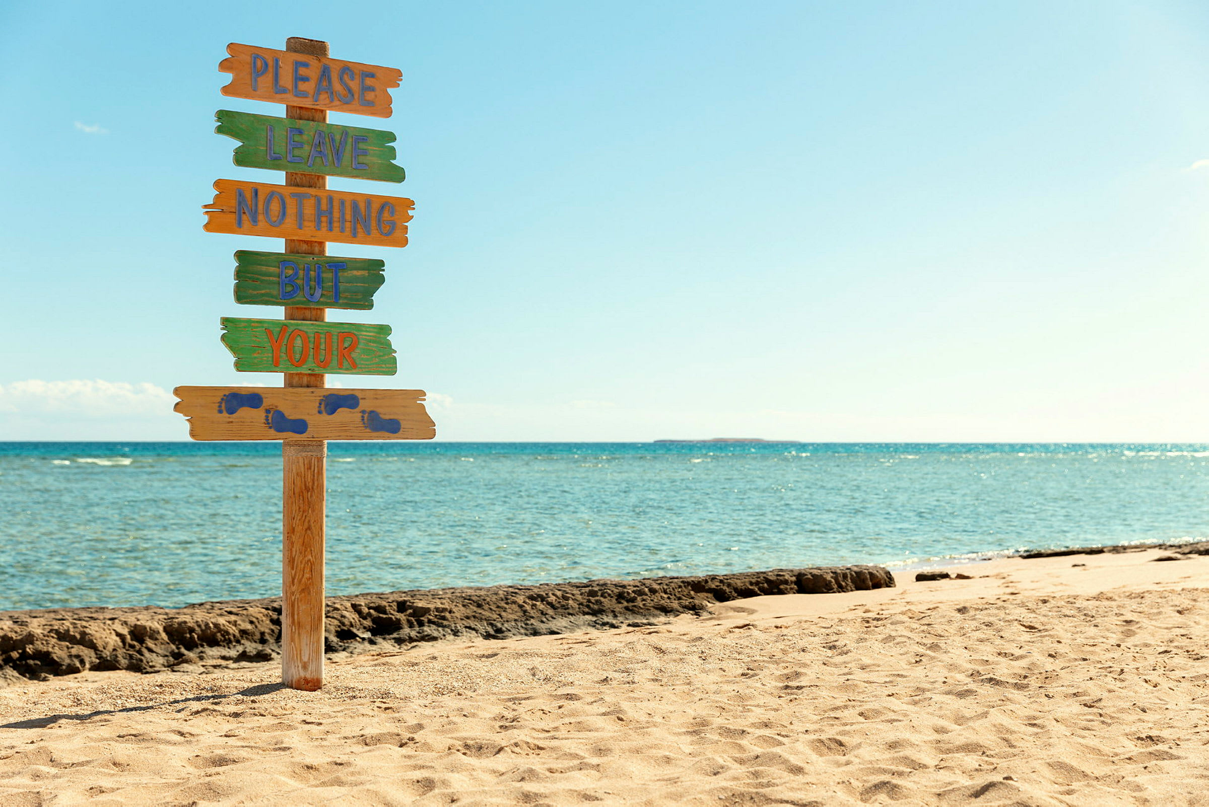 Skilt på strand med tekst som oppfordrer til ikke å etterlate søppel. (AI-generert tekst)
