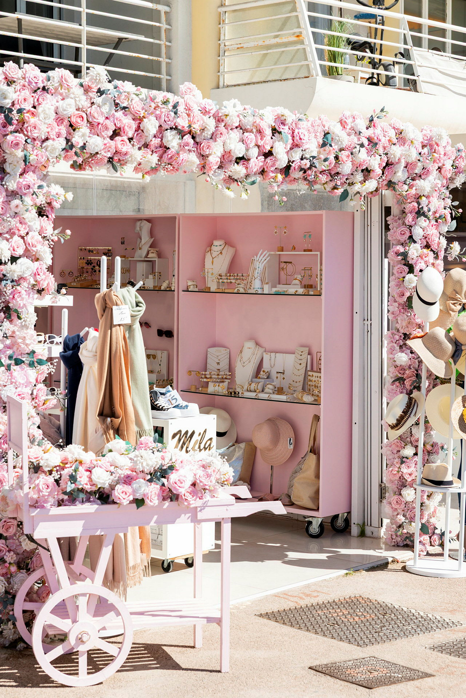 En butikk med rosa dekorasjoner og blomster, smykker og tilbehør vises. (AI-generert tekst)