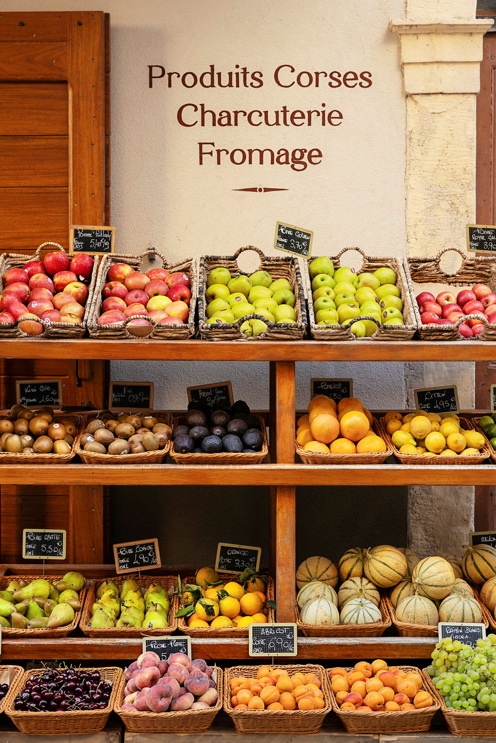 Frukt og grønnsaker er radet opp i kurver på en hylle. (AI-generert tekst)