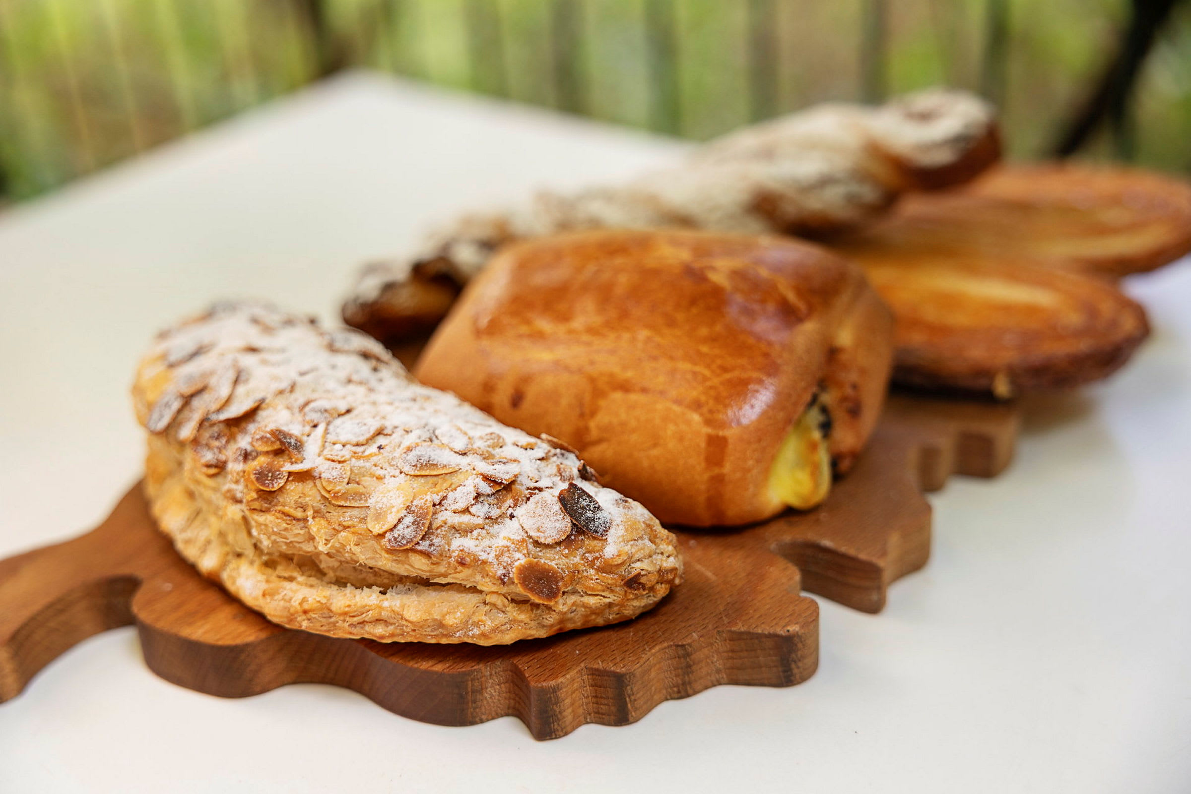 En treplate med forskjellige bakverk, inkludert en mandelcroissant med melis. (AI-generert tekst)