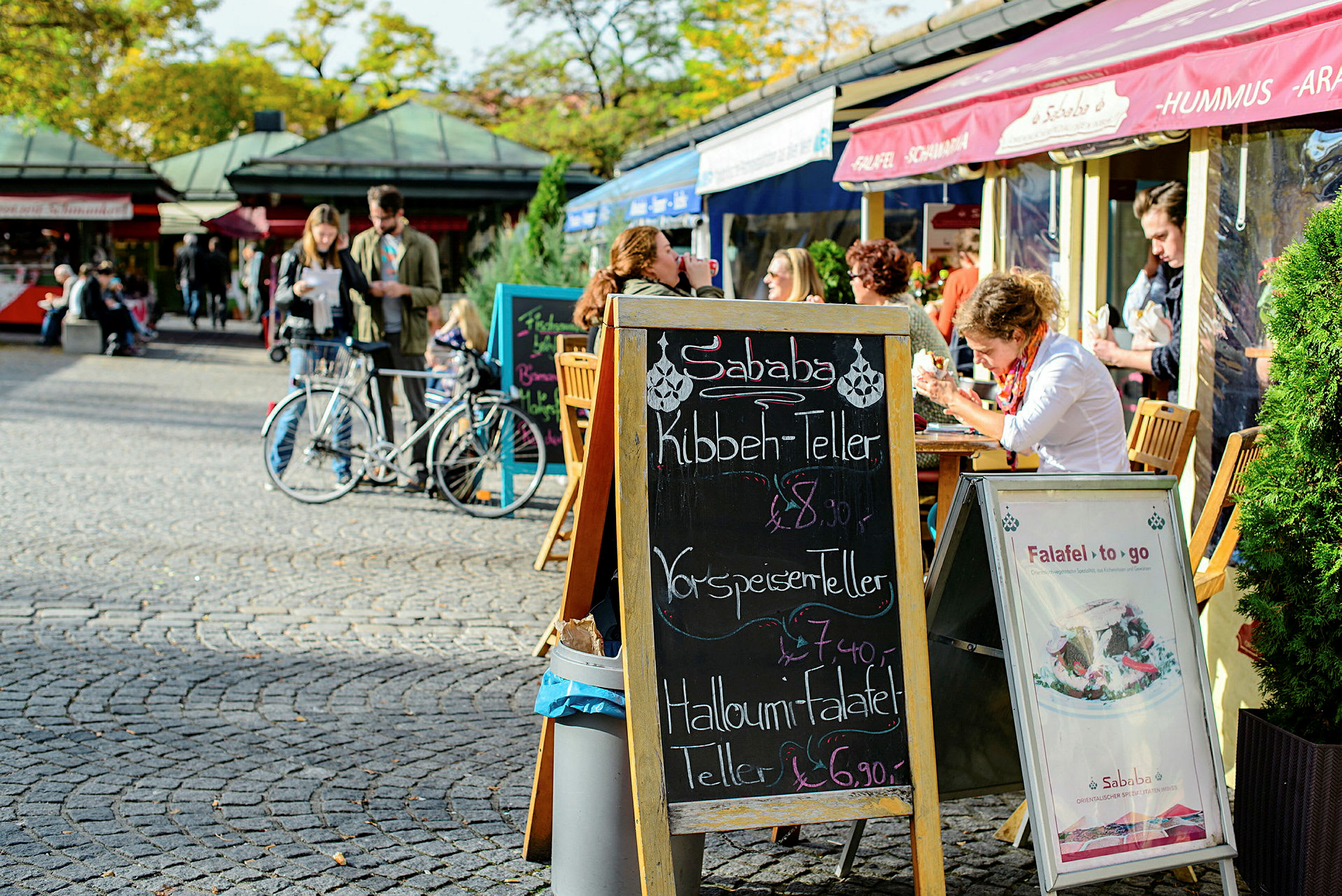 En gatekafé med uteservering og en meny på svarte tavletavlen. (AI-generert tekst)