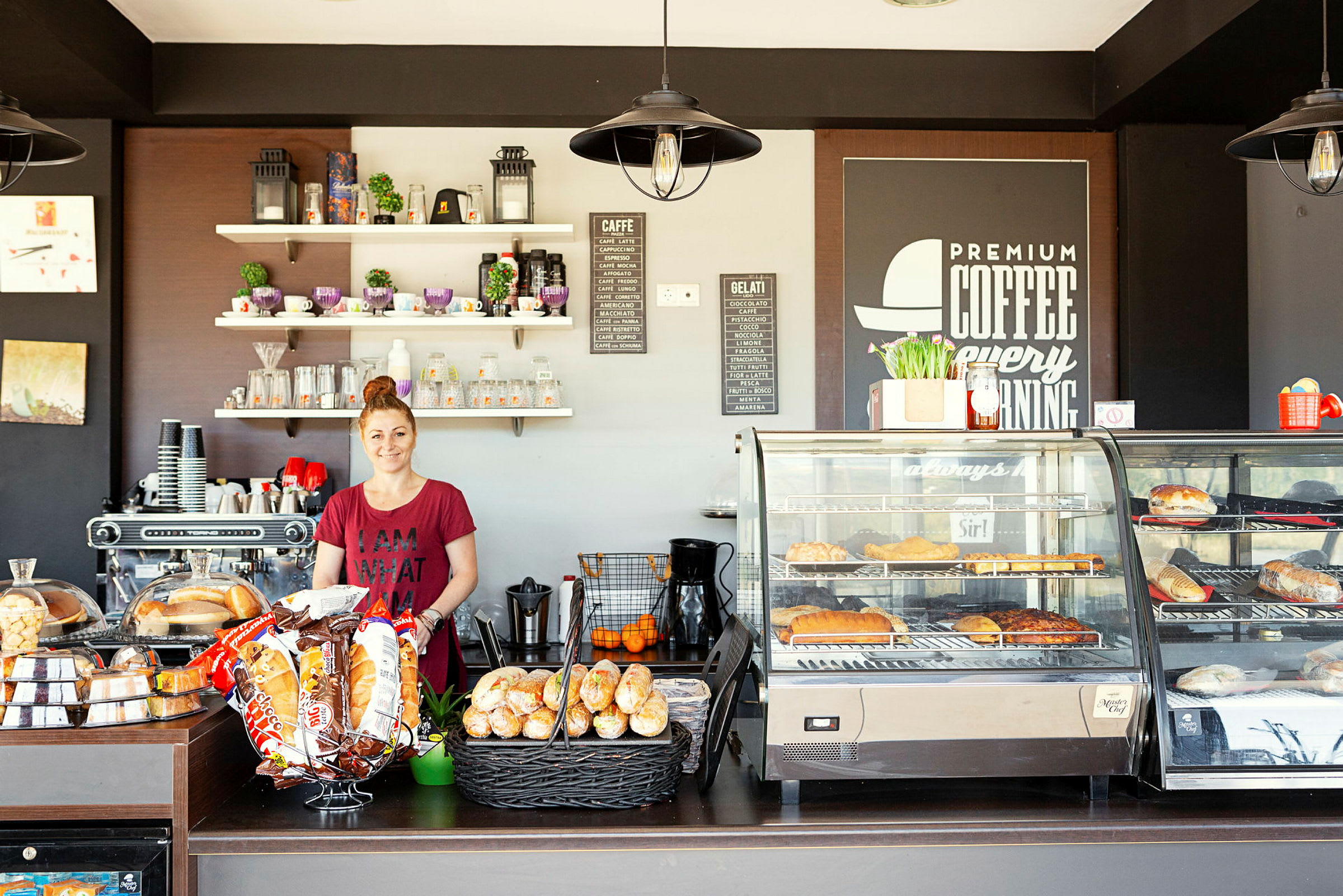 En serveringsdisk på en kafé, med hyller, kaffemaskin og bakevarer. (AI-generert tekst)