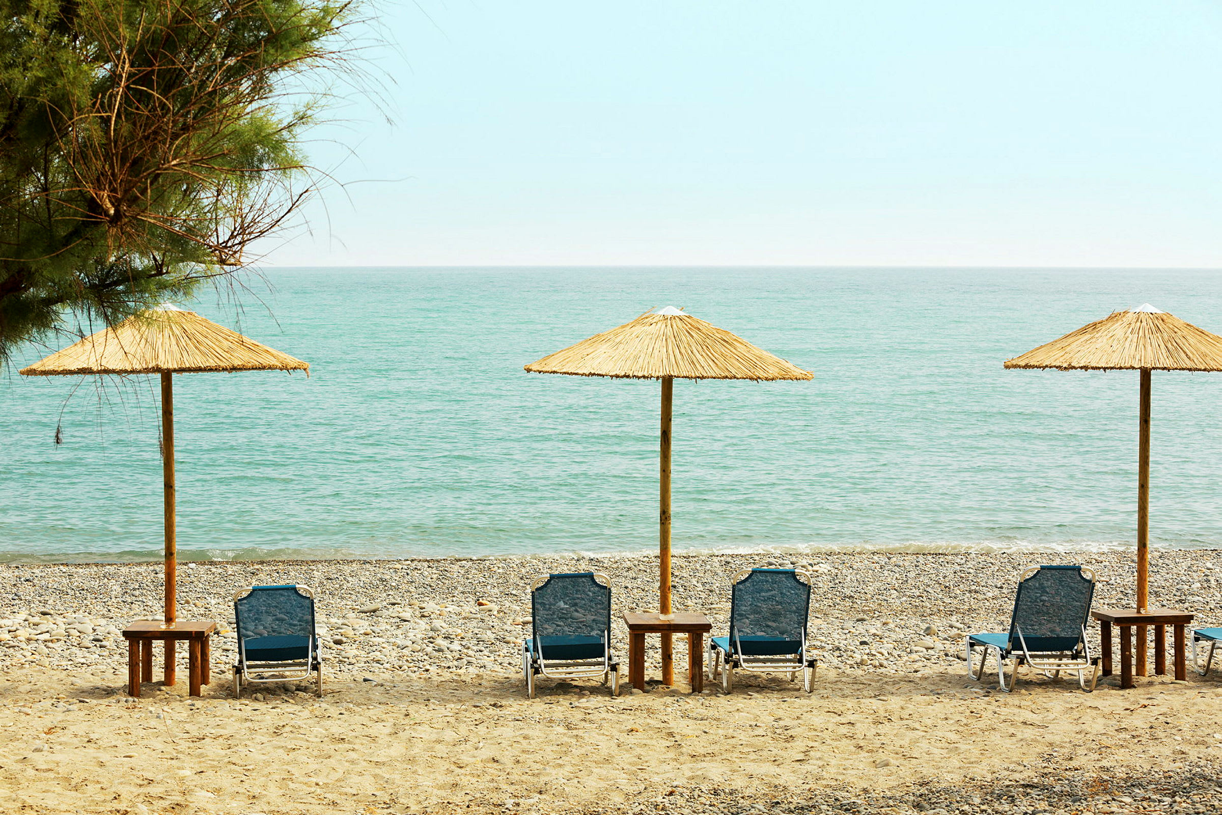 Solsenger med parasoller på en strand. (AI-generert tekst)