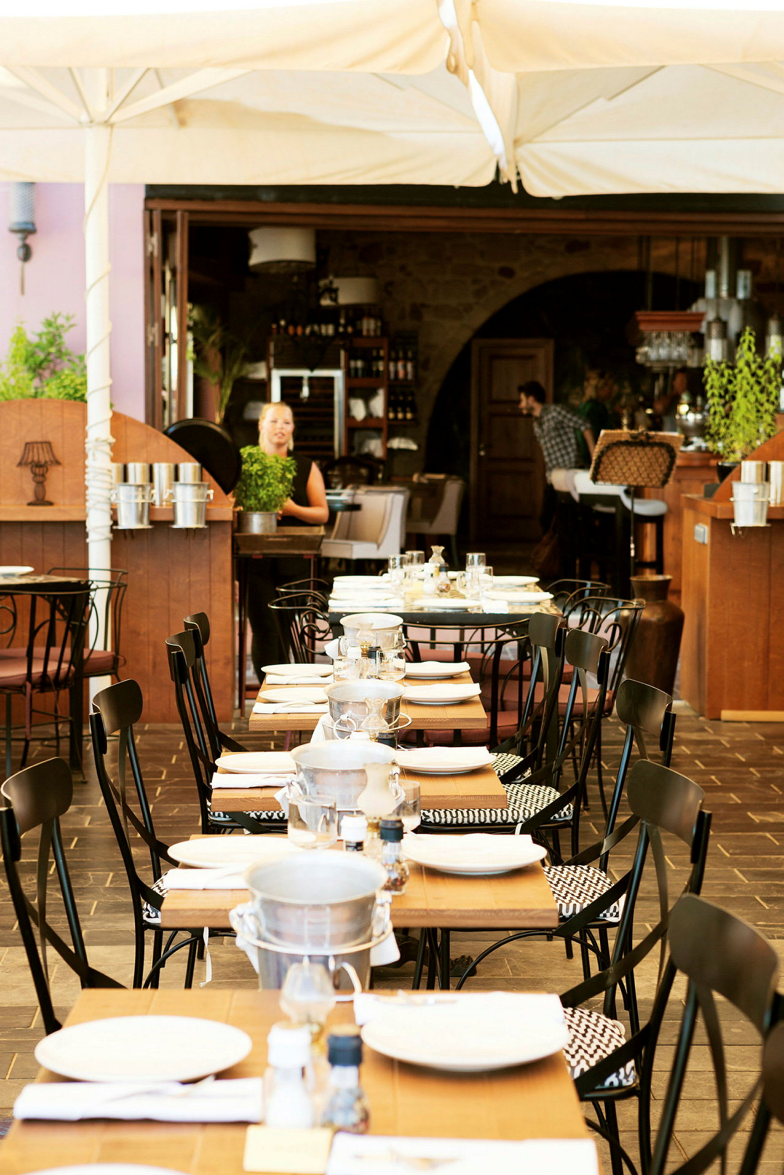 En restaurant med dekkede bord utendørs under et telt. (AI-generert tekst)