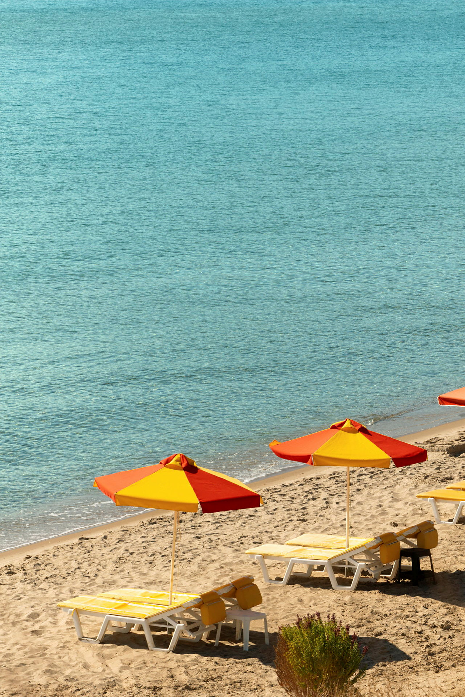Strand med parasoller og solsenger. (AI-generert tekst)