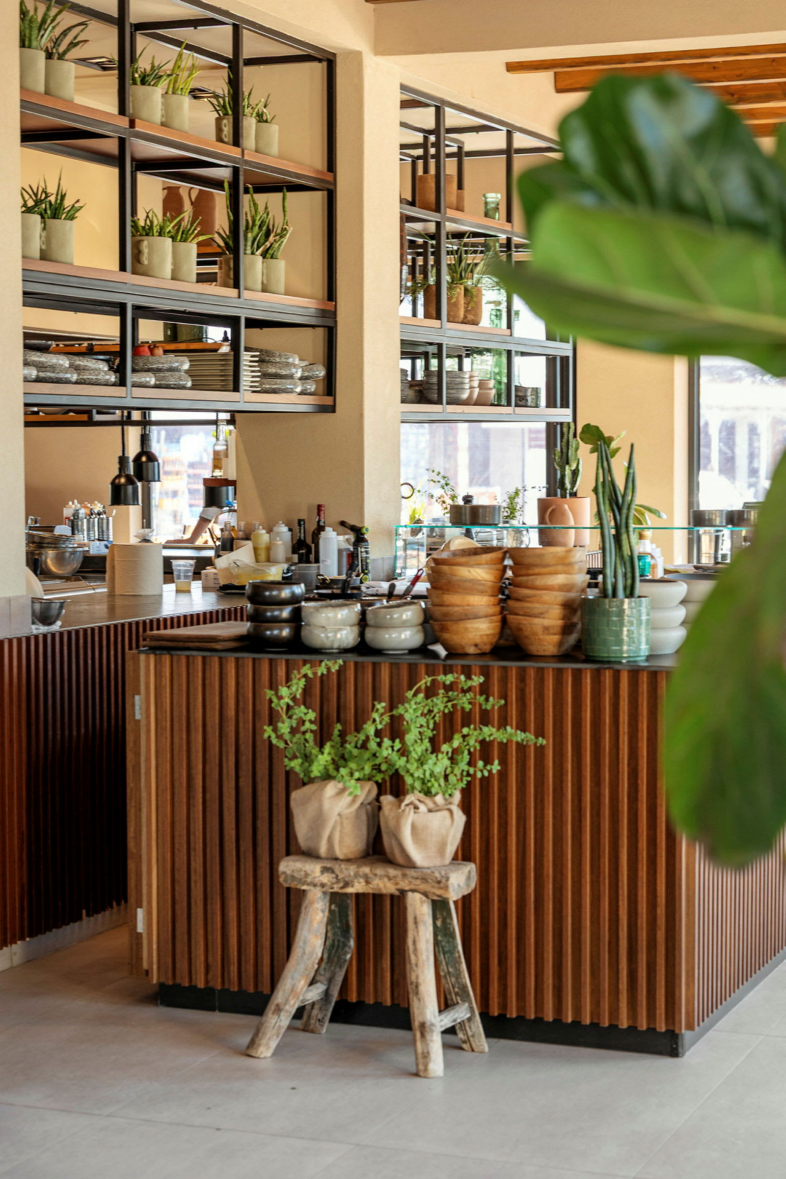 En moderne kafé med dekorative planter og treinnslag. (AI-generert tekst)