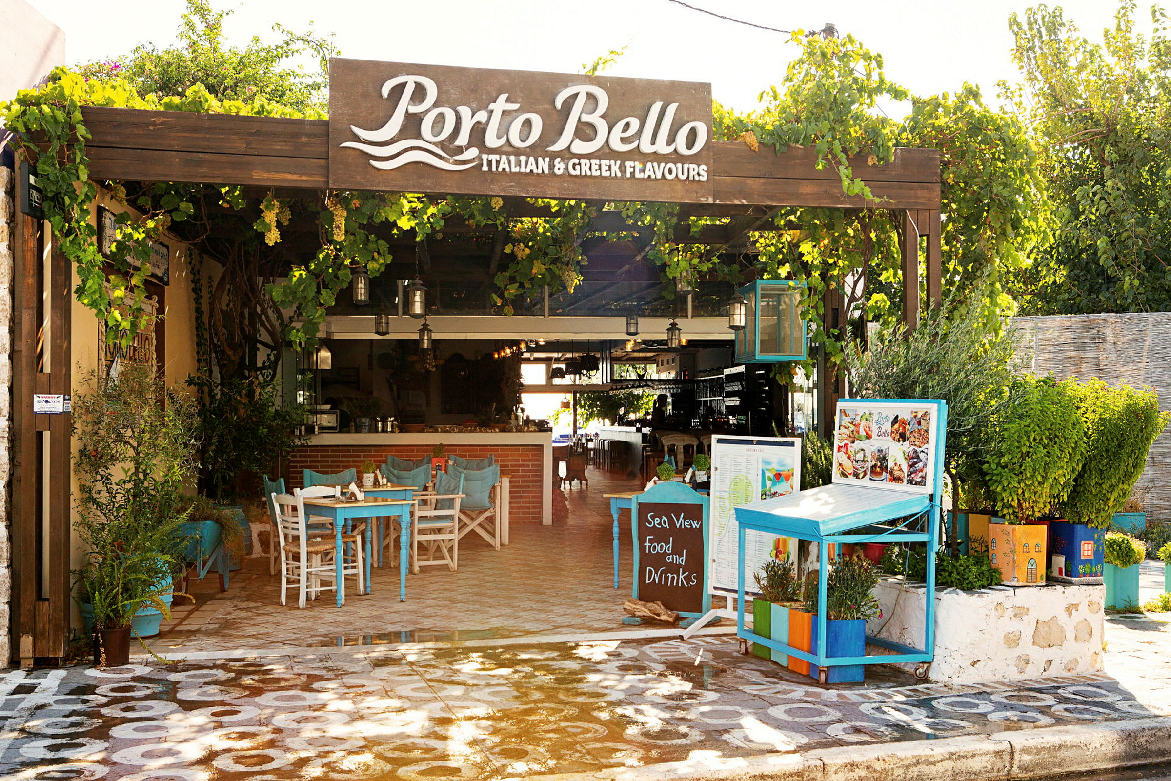 Bilde av en utendørsrestaurant kalt Porto Bello med bord og planter. (AI-generert tekst)