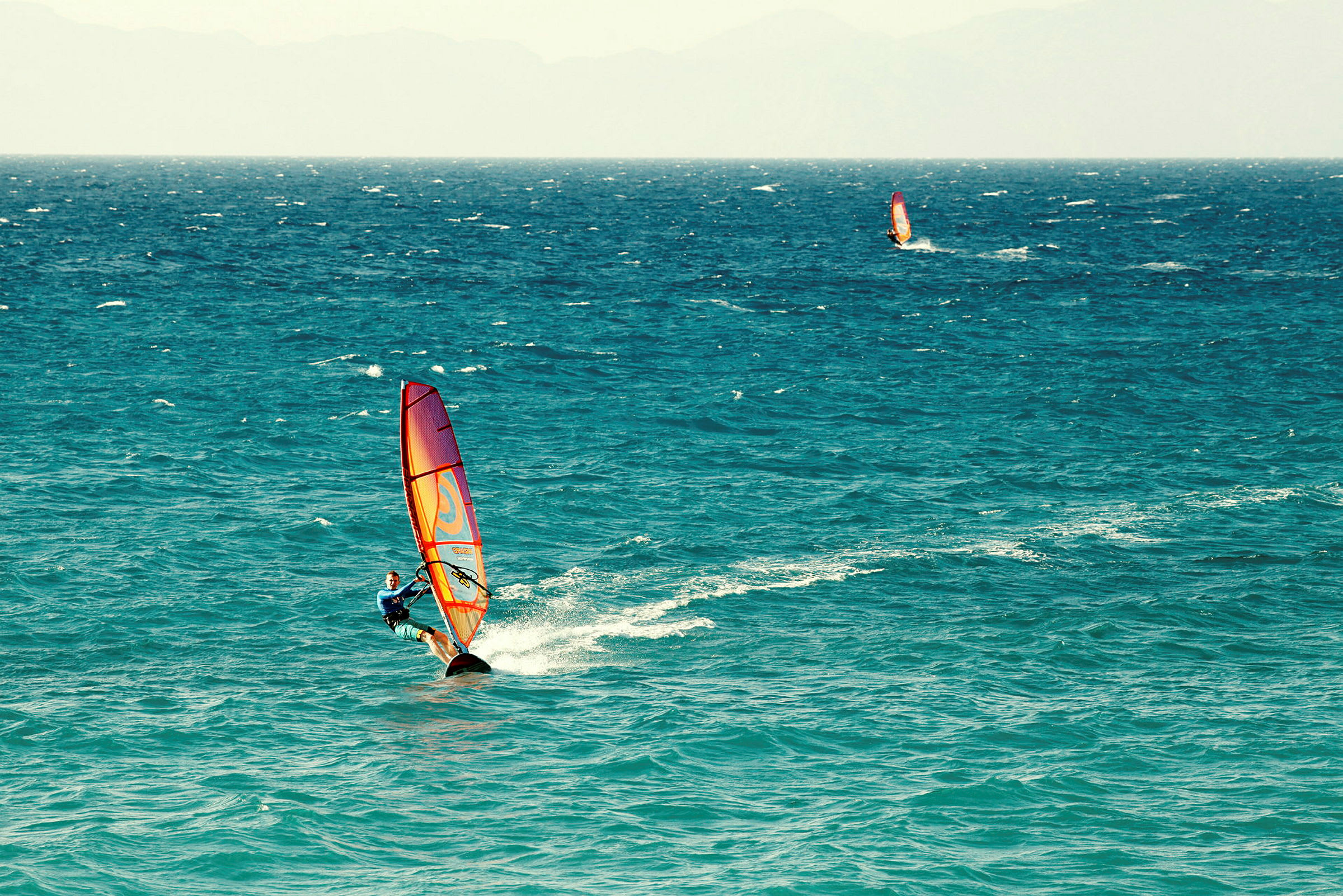 Person windsurfer på havet. (AI-generert tekst)