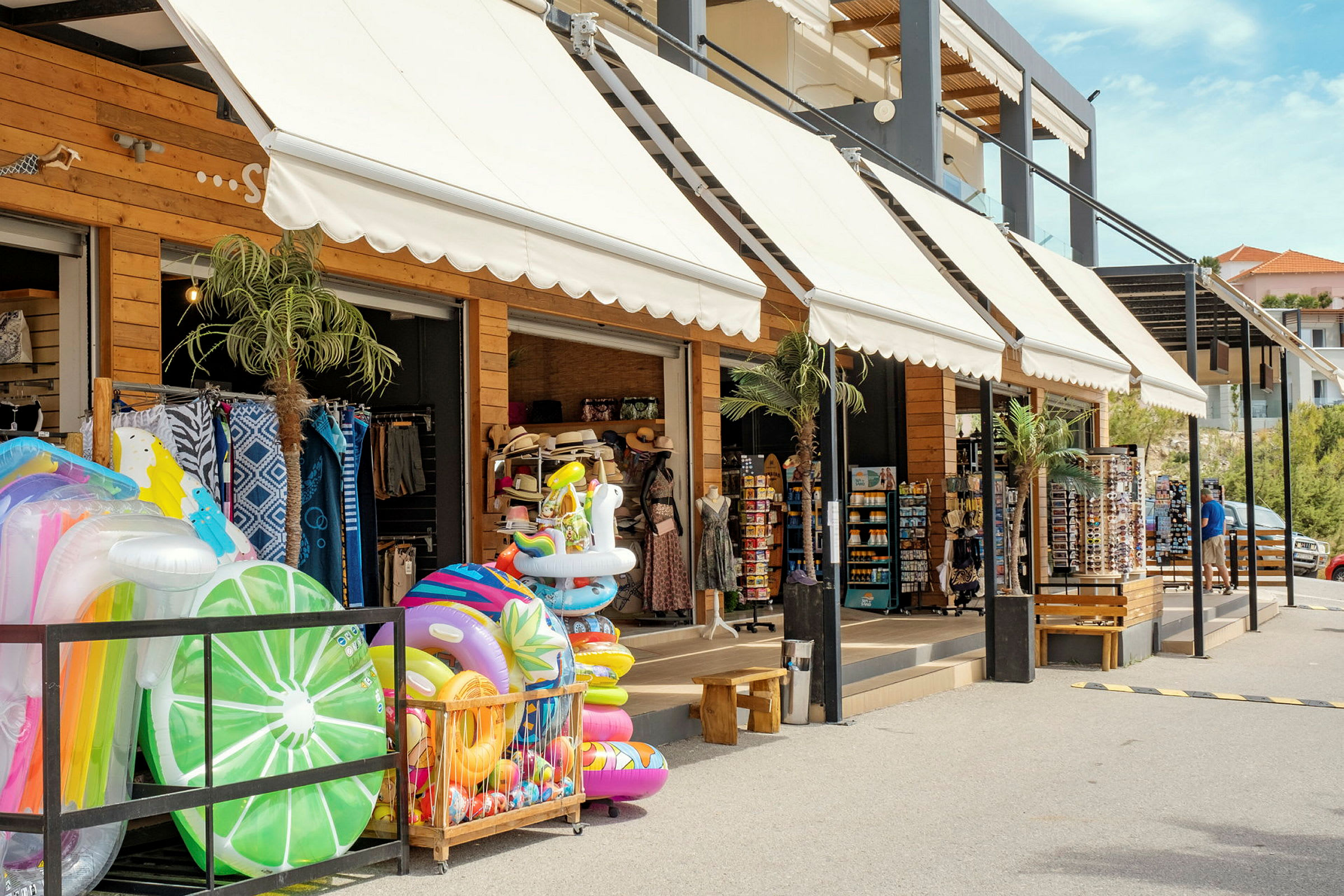 Butikk med oppblåsbare badeleker og ferieartikler utstilt utenfor. (AI-generert tekst)