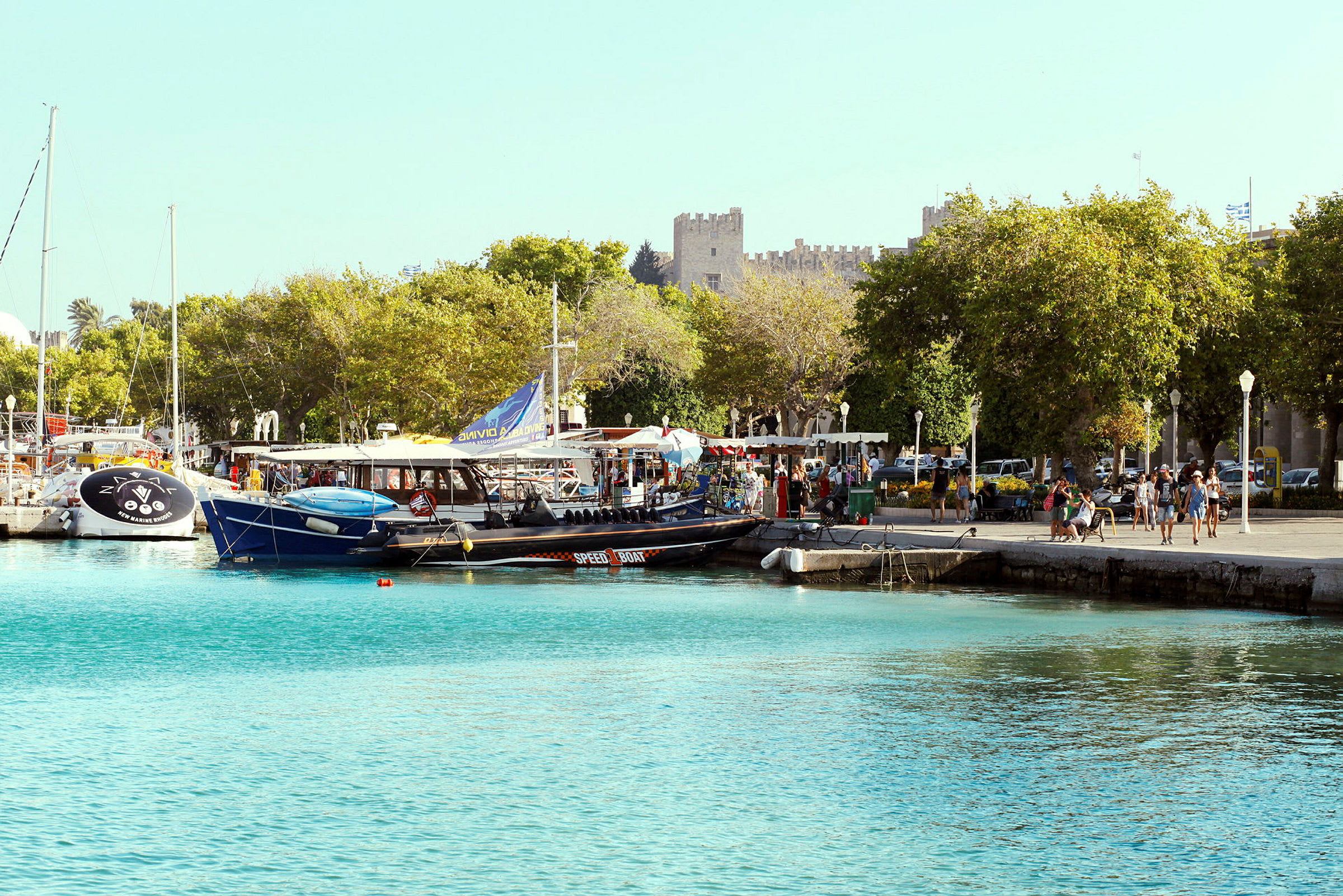 Havnpromenade med båter og grøntområder. (AI-generert tekst)