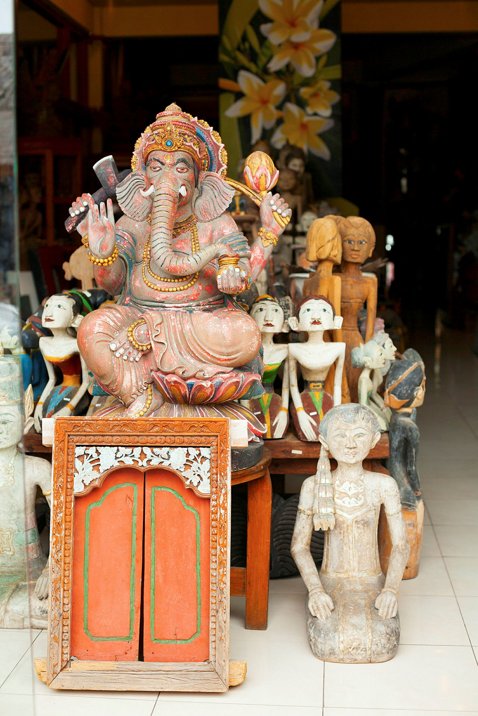 Dekorert statue av Ganesha og andre skulpturer plassert på en butikkhylle. (AI-generert tekst)
