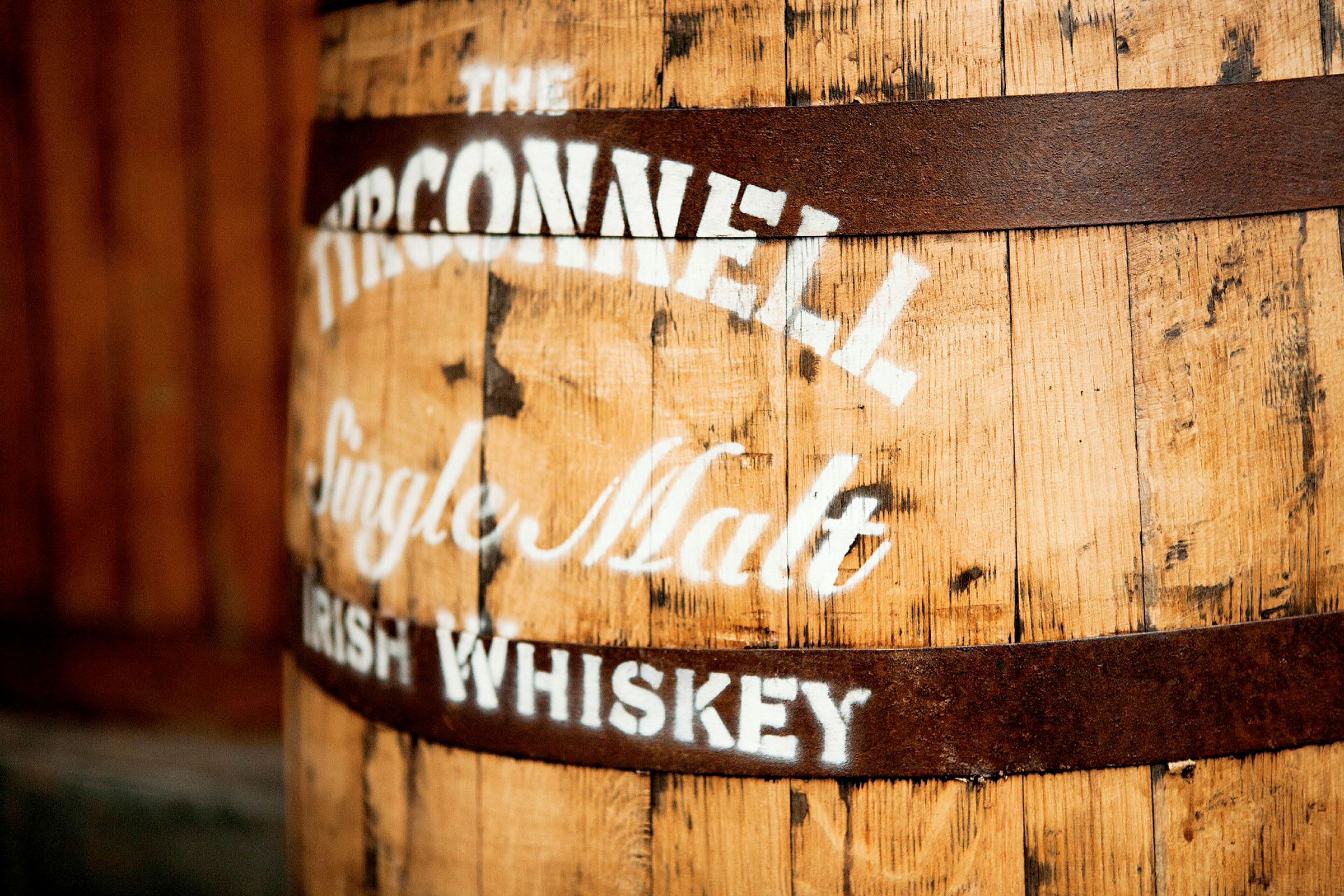 En gammel tretønne med en tekst som sier "The Tyrconnell Single Malt Irish Whiskey" malt på overflaten. (AI-generert tekst)