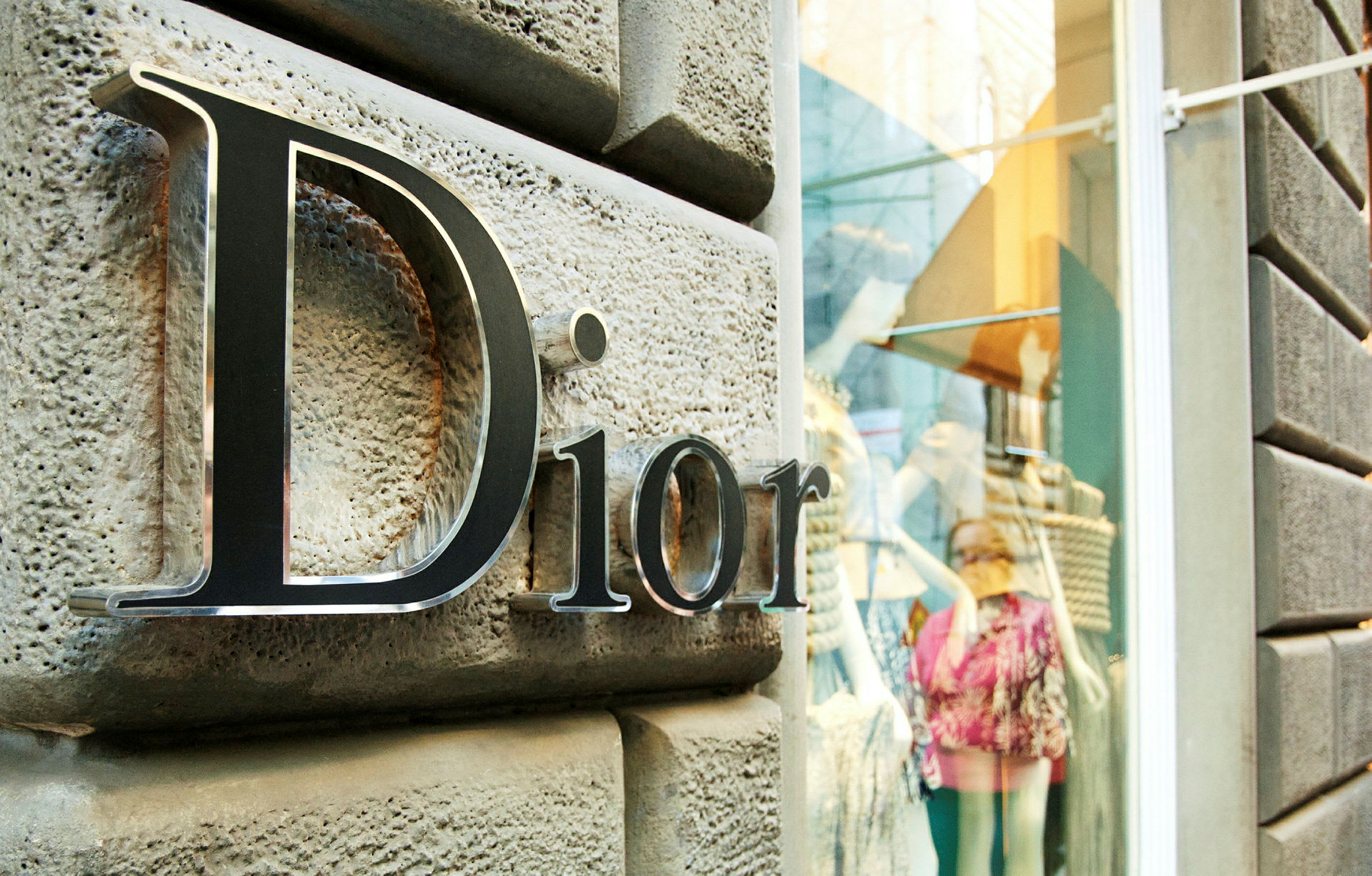 Dior-skilt utenfor en butikk med utstillingsvindu. (AI-generert tekst)