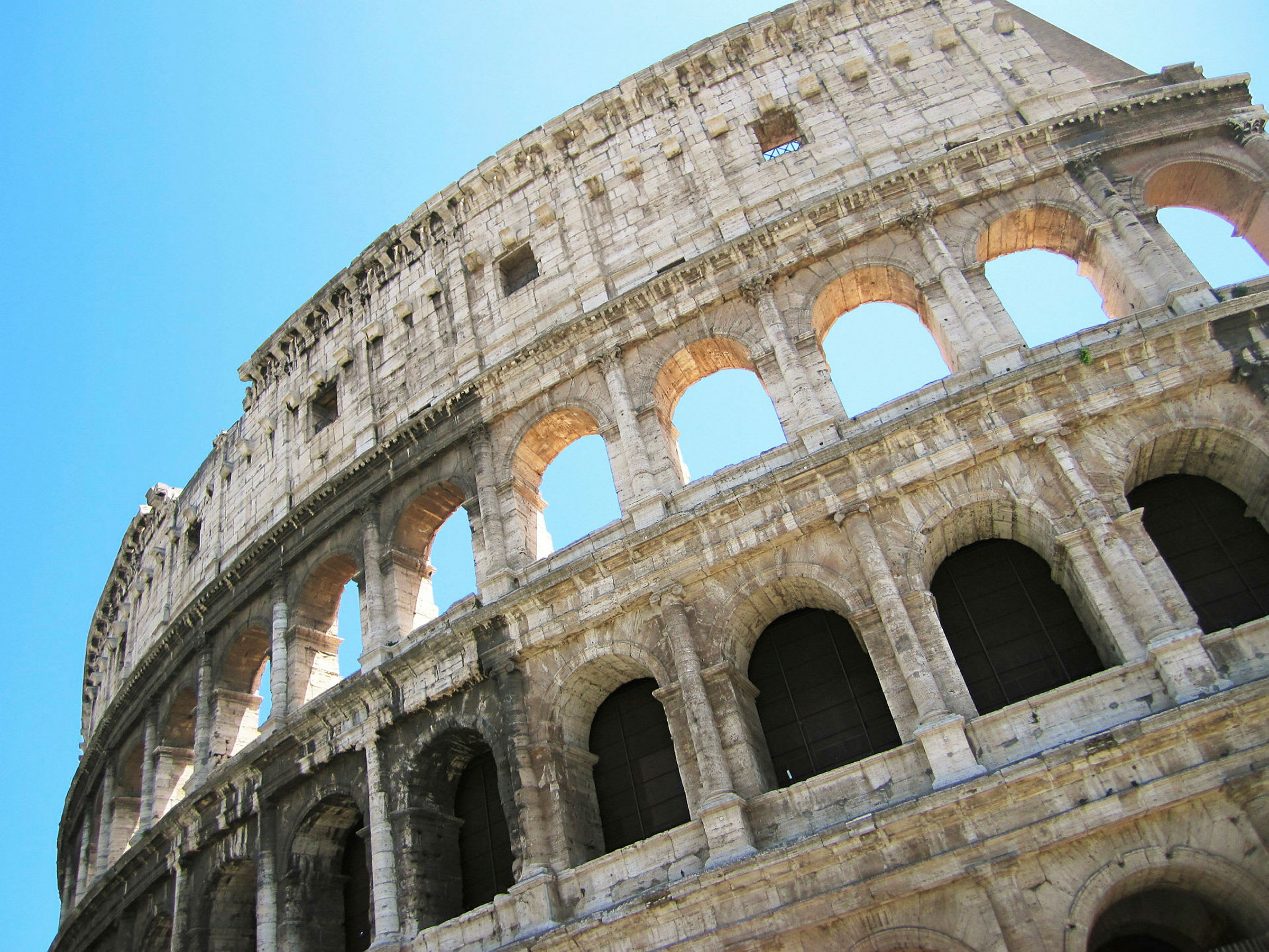 Et fotografi av Colosseum i Roma, Italia, mot en klar blå himmel. (AI-generert tekst)